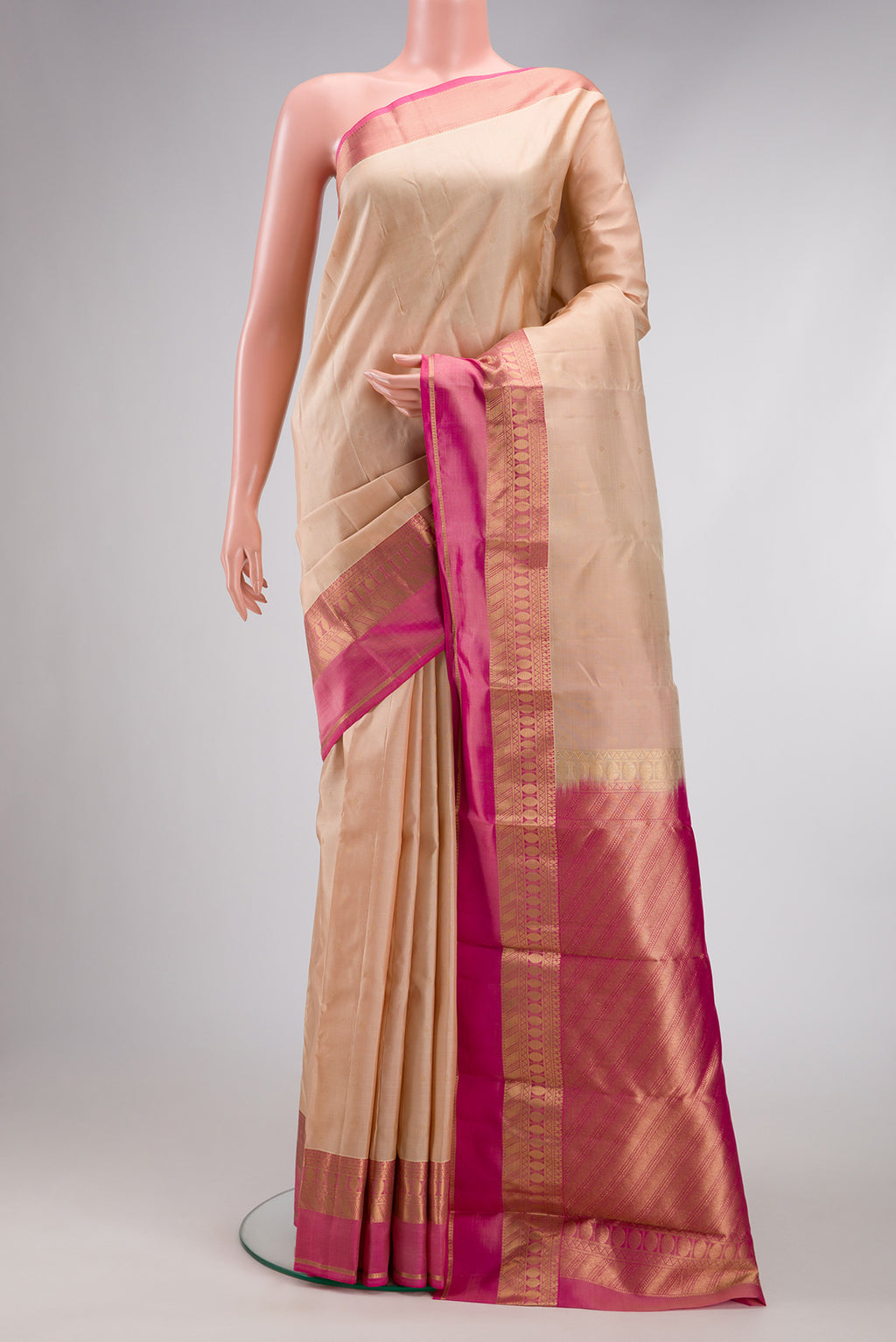 Beige Kanchipuram Silk Saree with Zari Butta on the body and Zari Border.  displayed on a mannequin
