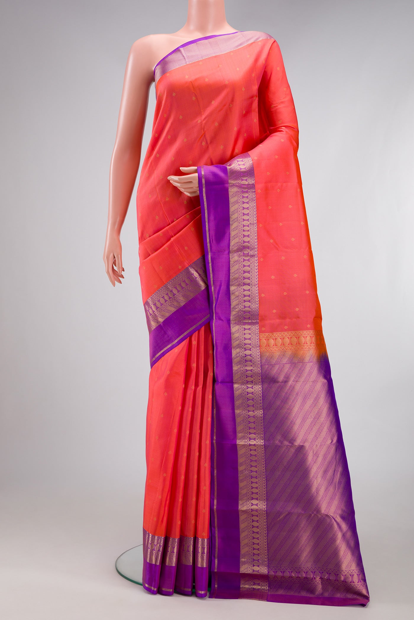 Coral Kanchipuram Silk Saree with Zari Butta on the body and Zari Border.  displayed on a mannequin