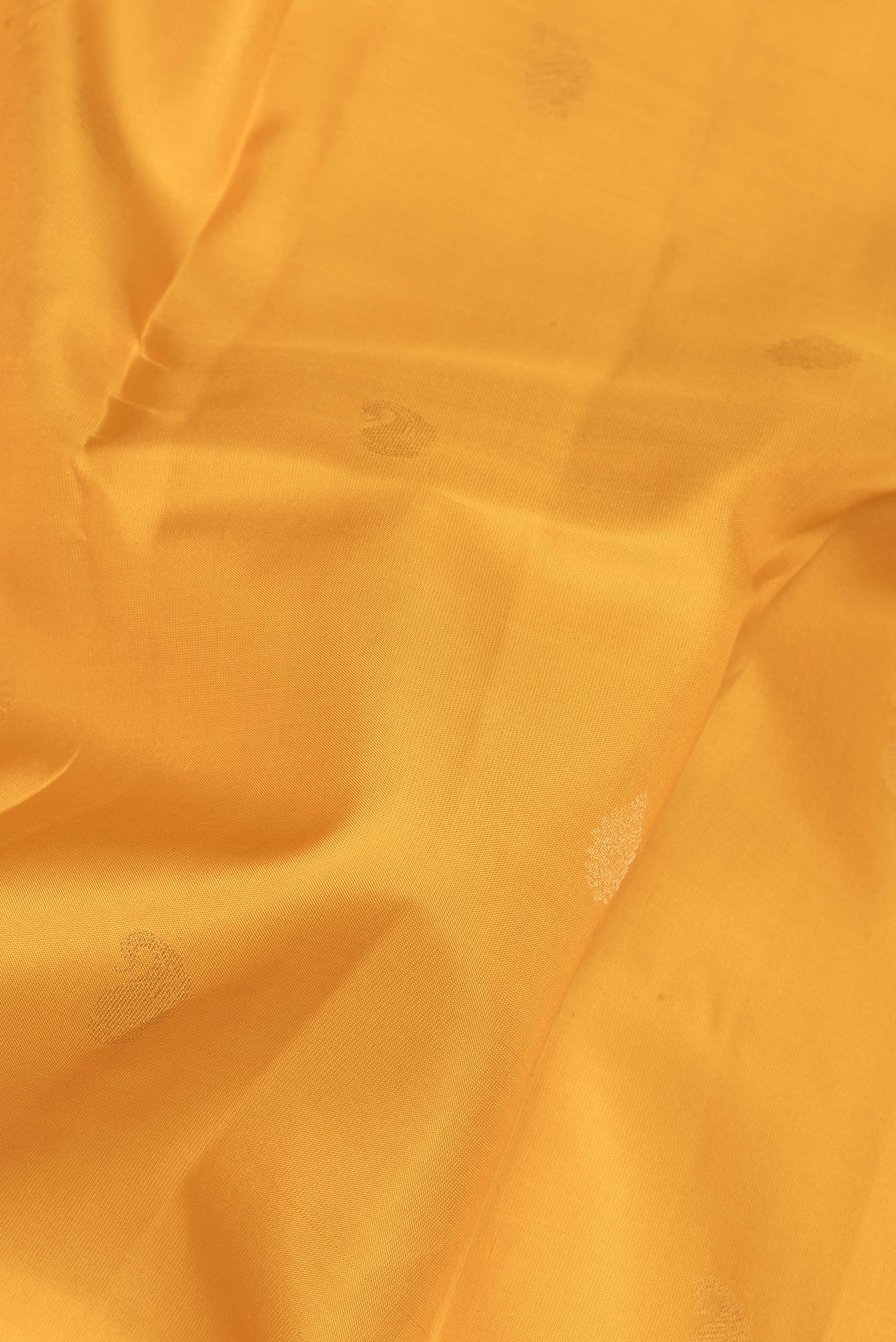 Close up of Yellow Kanchipuram Silk Saree with Zari Butta on the body and Zari Border.  displaying folds