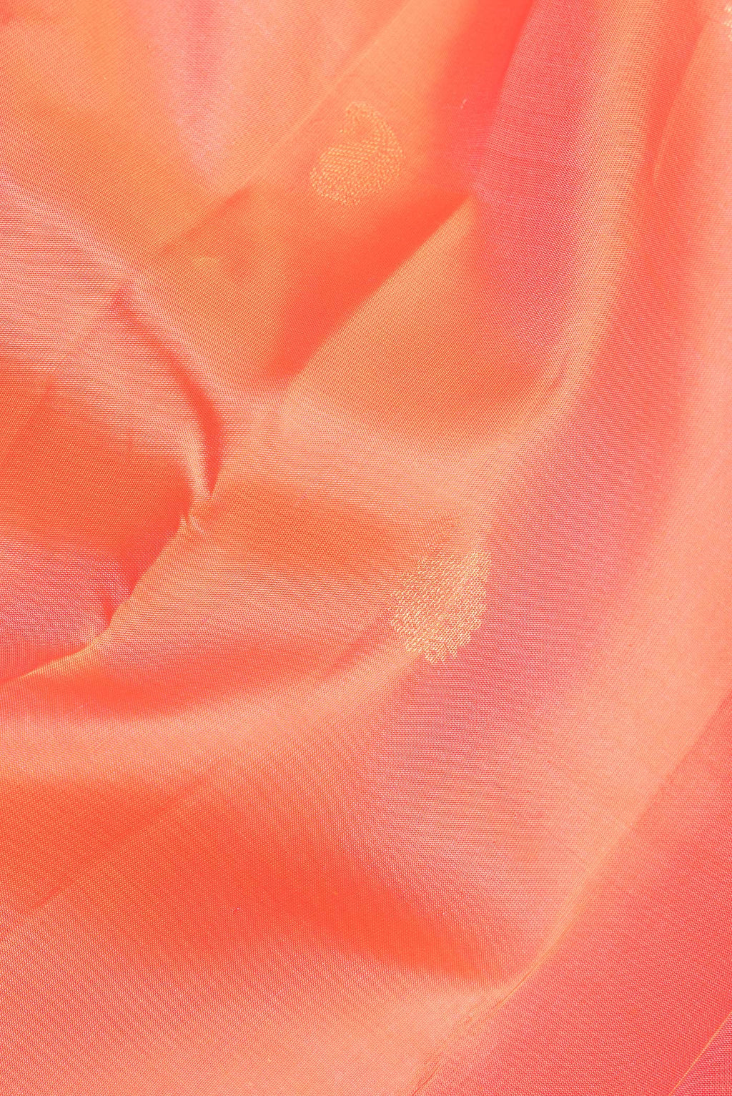 Close up of Pure Silk Orange Kanchipuram Saree with Zari Butta on the body and Zari Border.  displaying folds