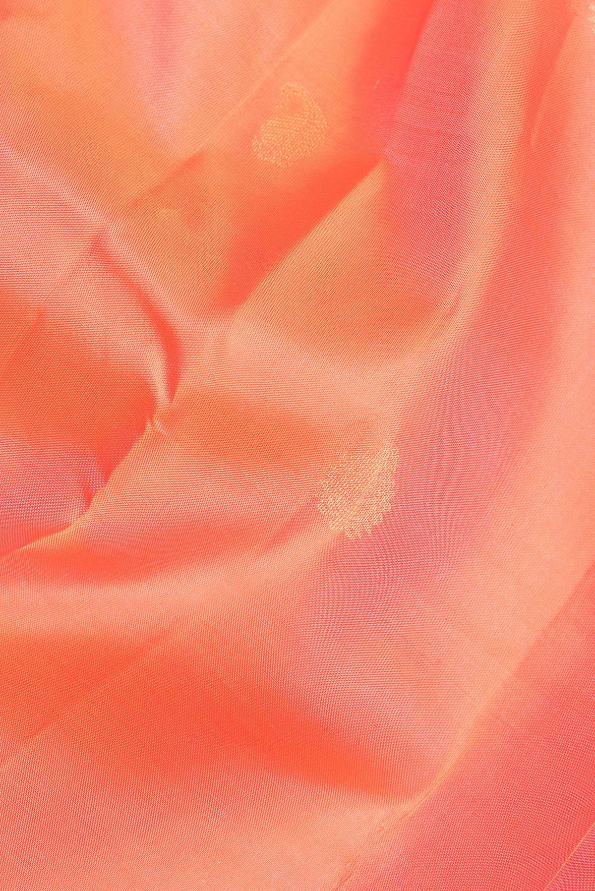Close up of Pure Silk Orange Kanchipuram Saree with Zari Butta on the body and Zari Border.  displaying folds