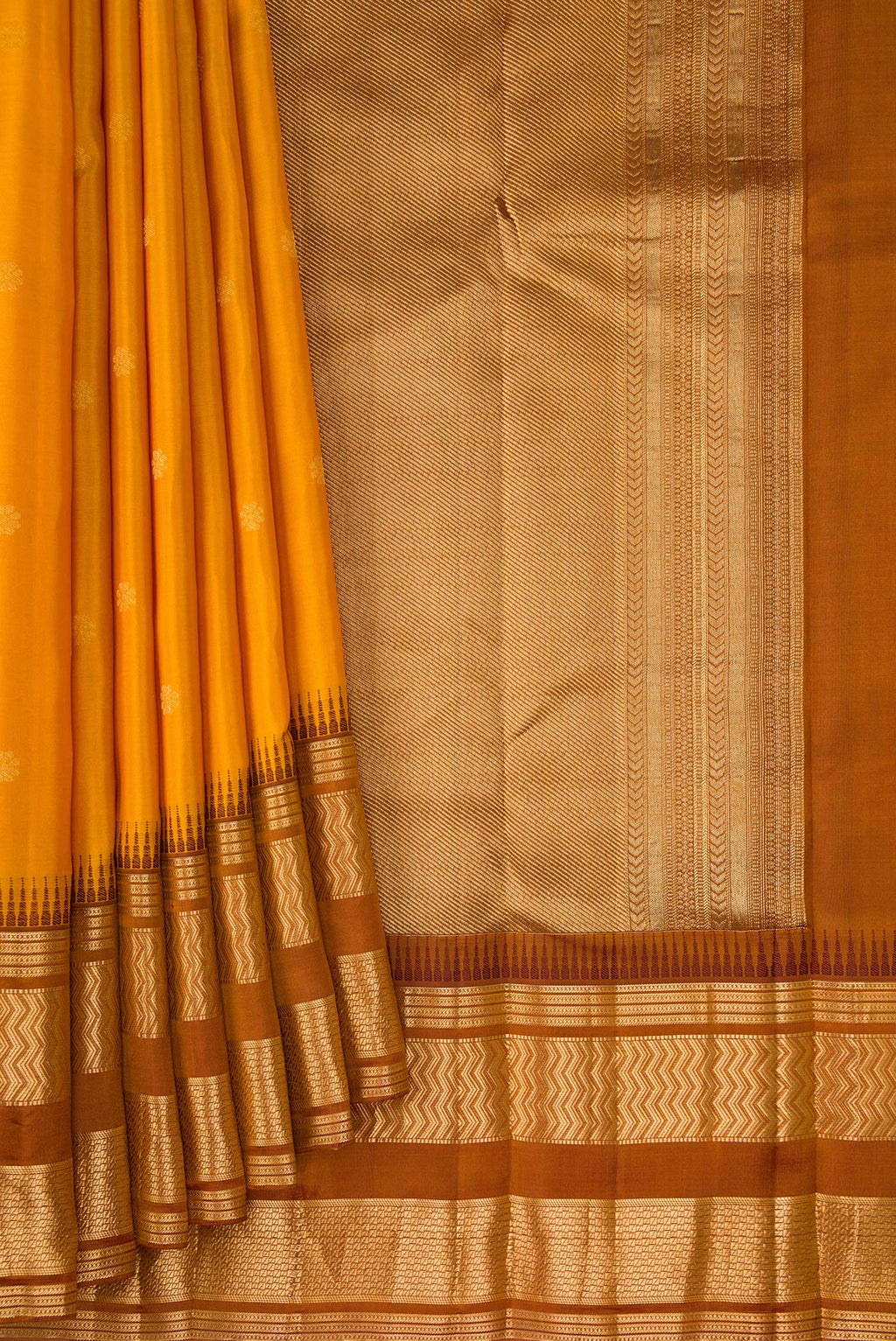 Pleats and pallu of Mustard Kanjivaram Silk Saree with Zari Butta on the body and Zari Border. 