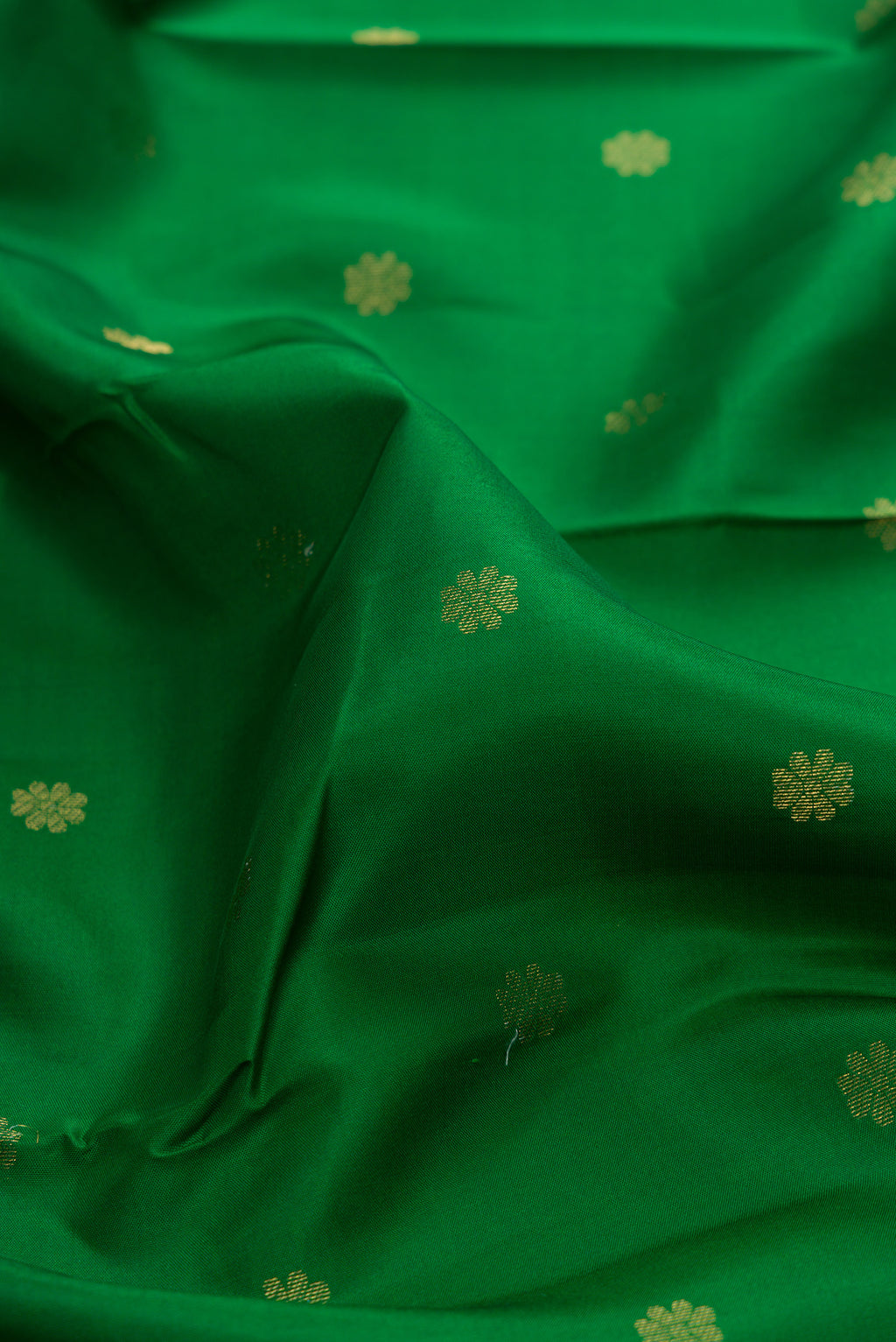 Close up of Green Kanjivaram Silk Saree with Zari Butta on the body and Zari Border.  displaying folds