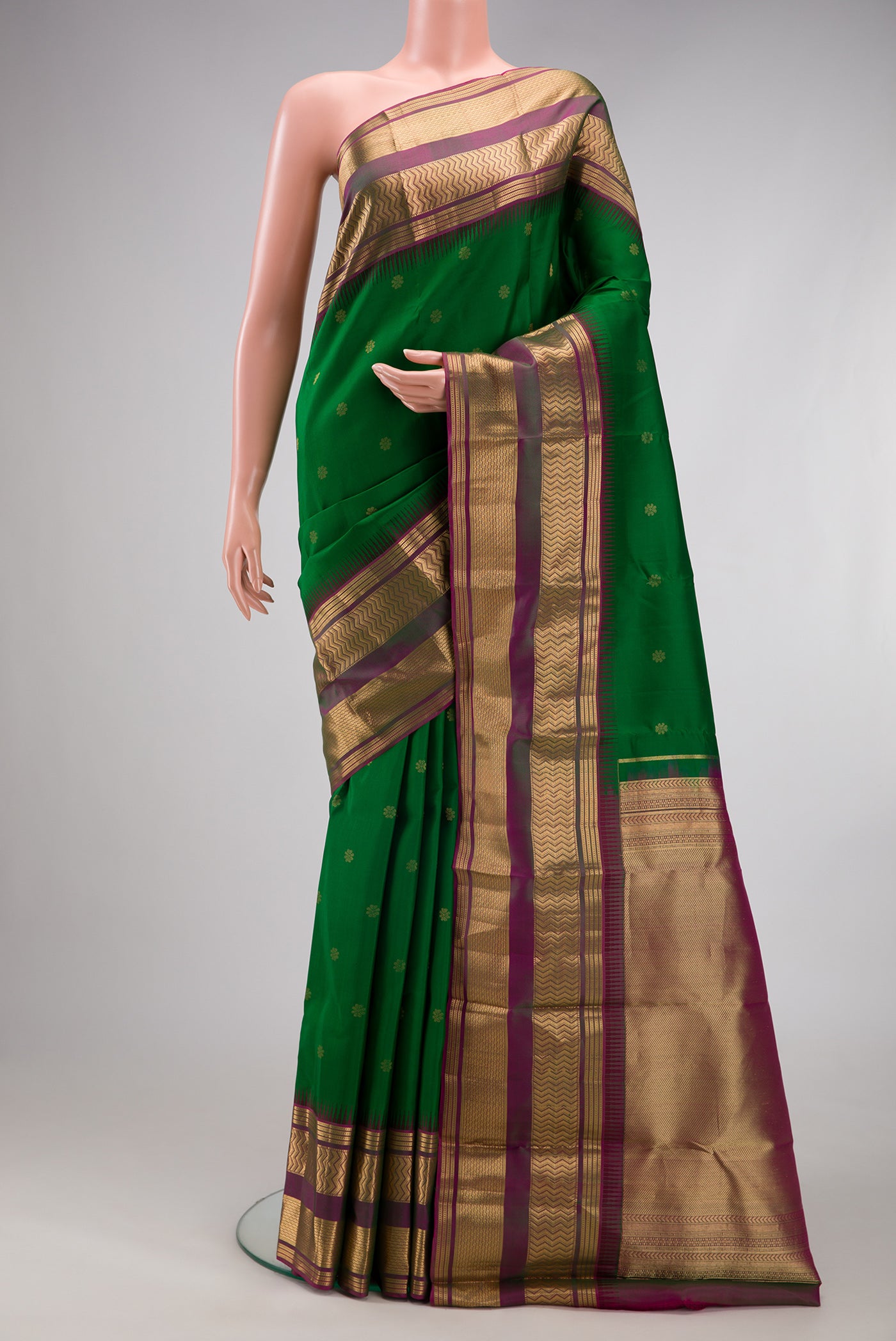 Green Kanjivaram Silk Saree with Zari Butta on the body and Zari Border.  displayed on a mannequin