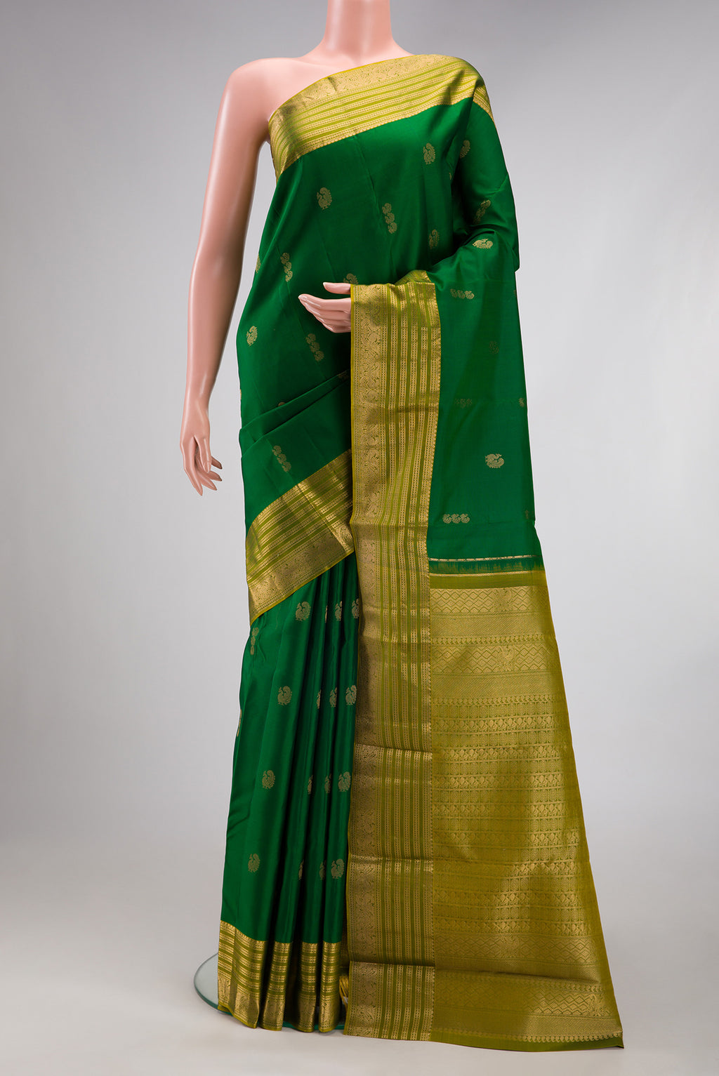Green Kanchipuram Silk Saree with Zari Butta on the body and Zari Border.  displayed on a mannequin