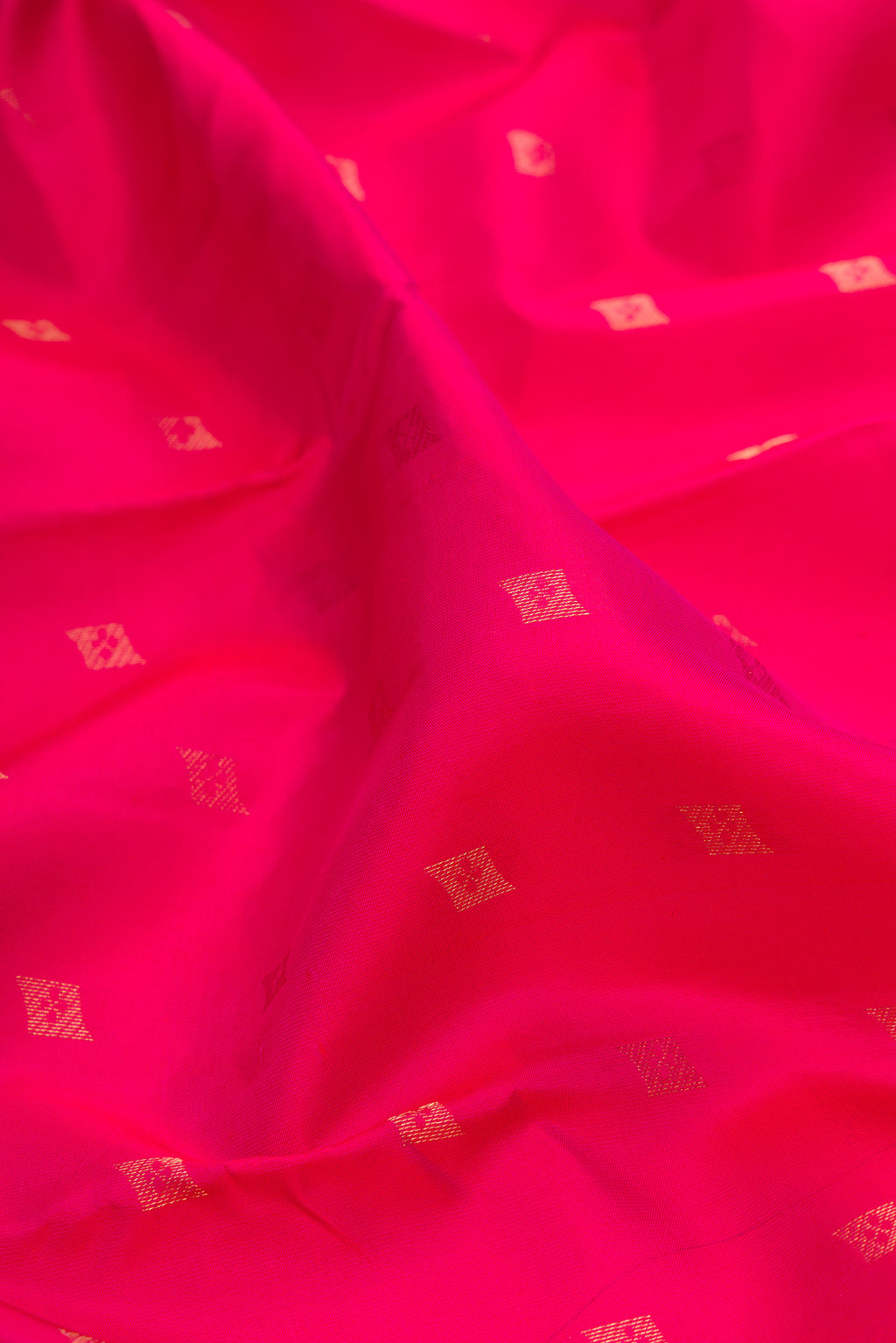 Close up of Dark Pink Kanchipuram Silk Saree with Zari Butta on the body and Zari Border.  displaying folds
