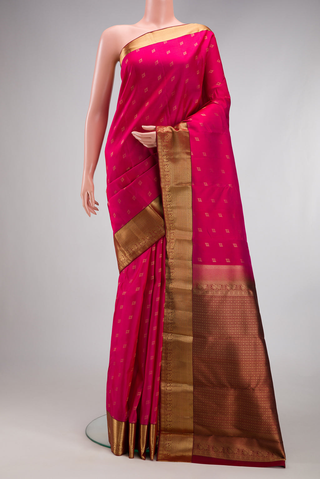 Dark Pink Kanchipuram Silk Saree with Zari Butta on the body and Zari Border.  displayed on a mannequin