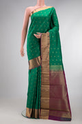 Green Kanchipuram Silk Saree with Zari Butta on the body and Zari Border.  displayed on a mannequin