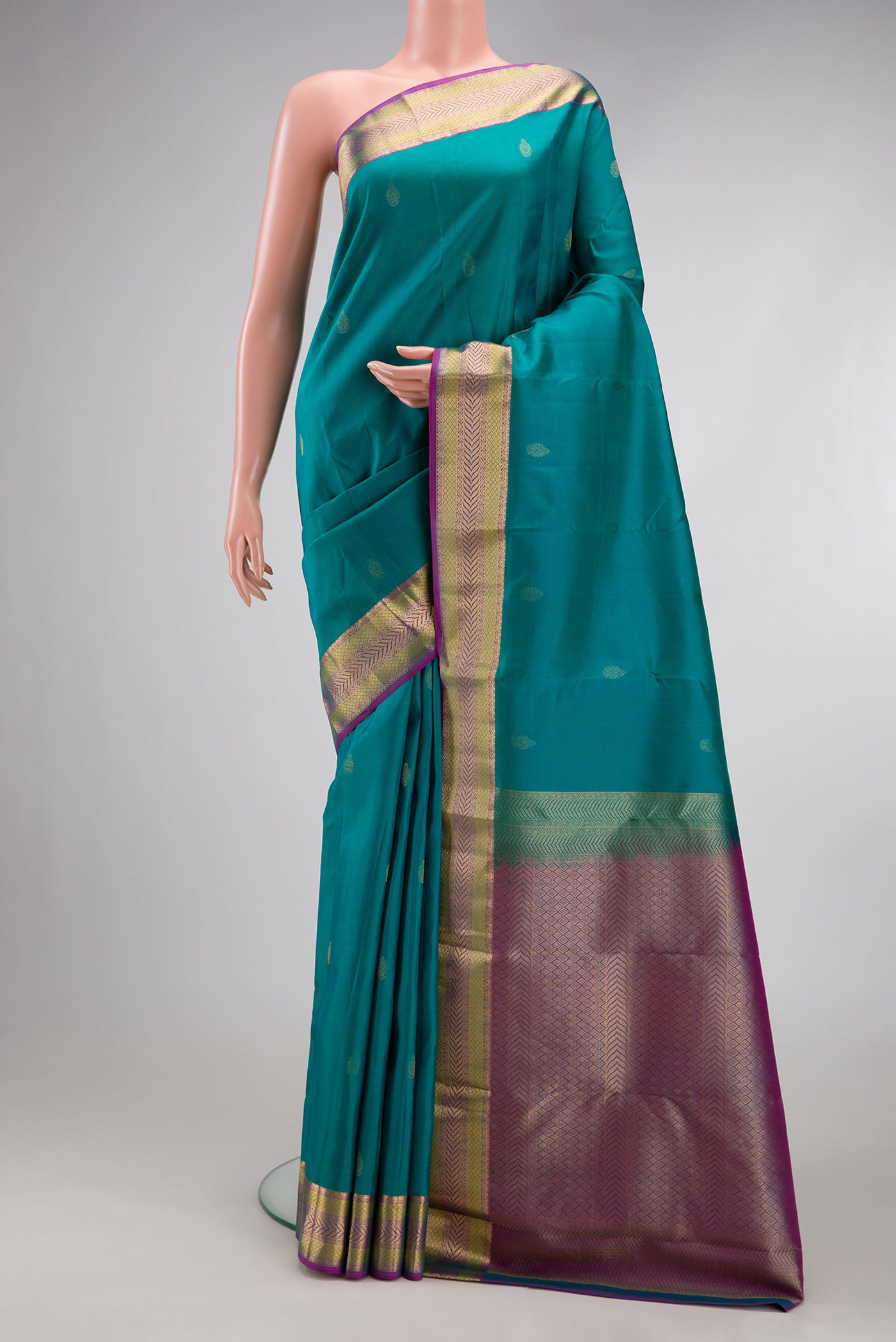 Teal Kanchipuram Silk Saree with Zari Butta on the body and Zari Border.  displayed on a mannequin