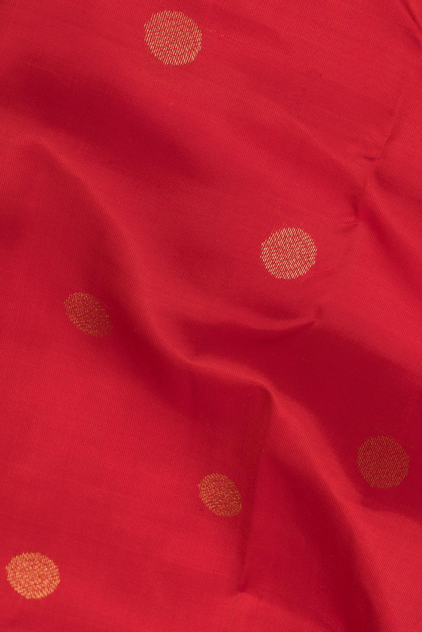 Close up of Red Kanchipuram Silk Saree with Zari Butta on the body and Zari Border.  displaying folds