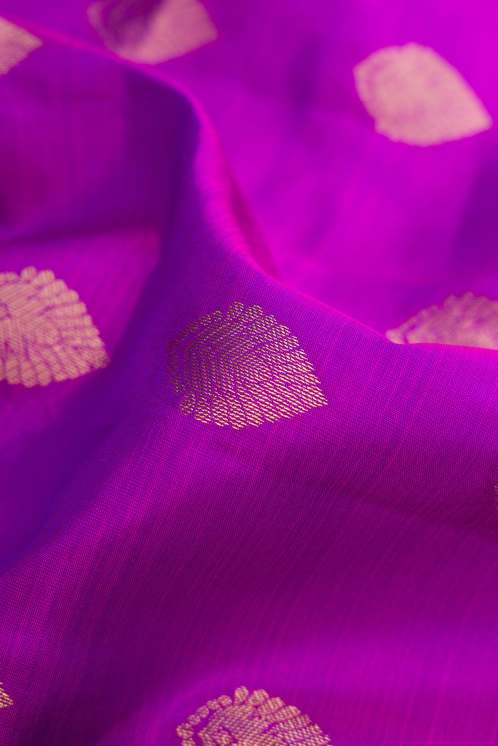 Close up of Purple Kanchipuram Silk Saree with Zari Butta on the body and Zari Border.  displaying folds