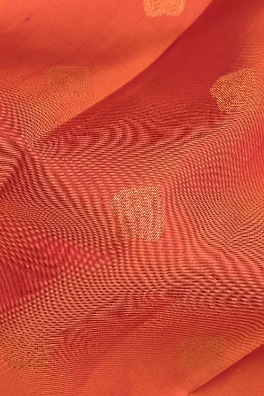 Close up of Pure Silk Orange Kanjivaram Saree with Zari Butta on the body and Zari Border.  displaying folds