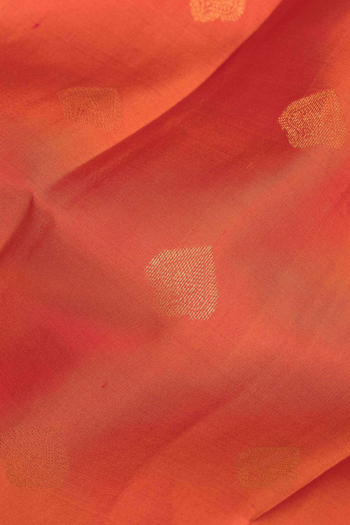 Close up of Pure Silk Orange Kanjivaram Saree with Zari Butta on the body and Zari Border.  displaying folds