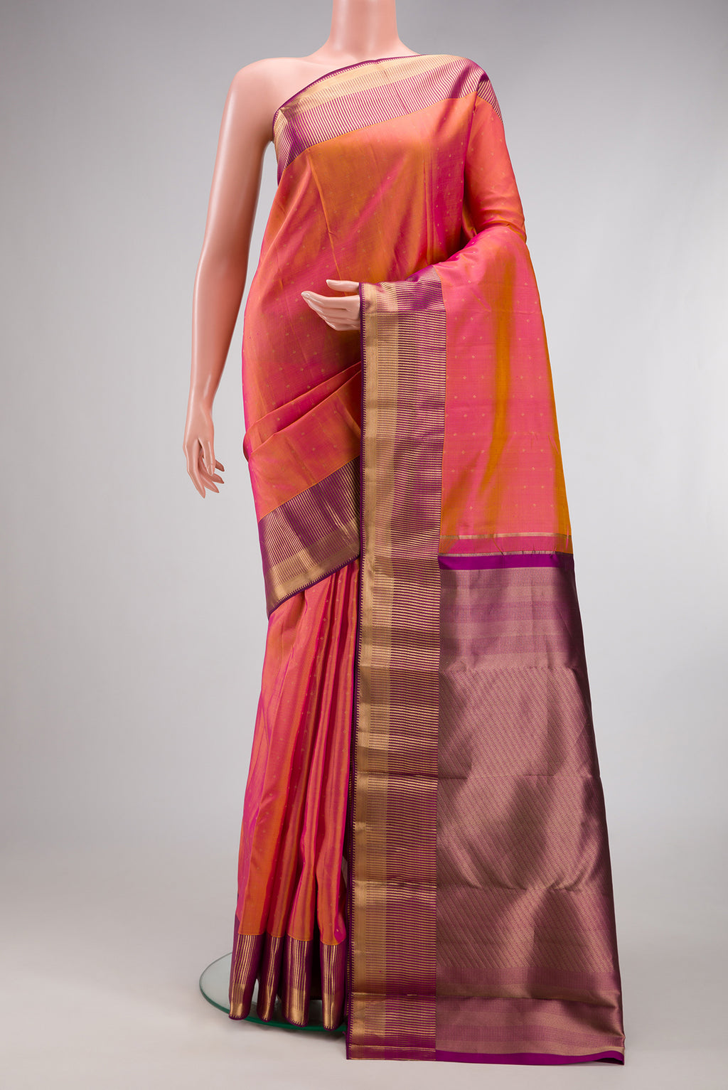 Pinkish Yellow Dual Tone Kanchipuram Silk Saree with Zari Butta on the body and Zari Border.  displayed on a mannequin