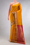 Mustard Kanchipuram Silk Saree with Zari Butta on the body and Zari Border.  displayed on a mannequin
