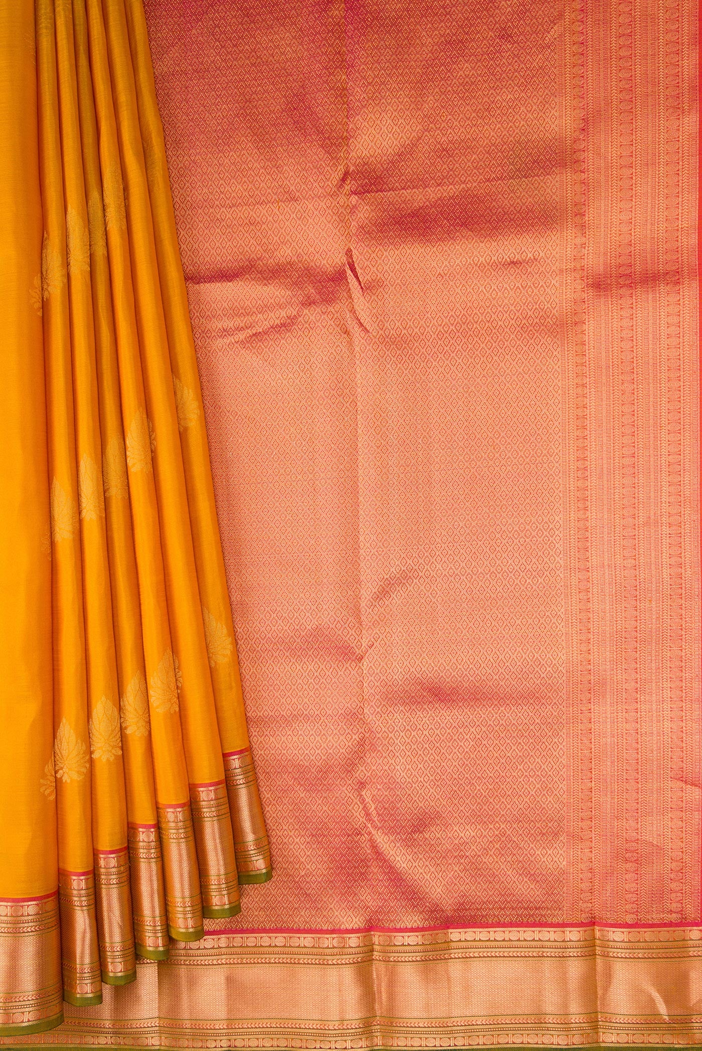 Pleats and pallu of Mustard Kanchipuram Silk Saree with Zari Butta on the body and Zari Border. 