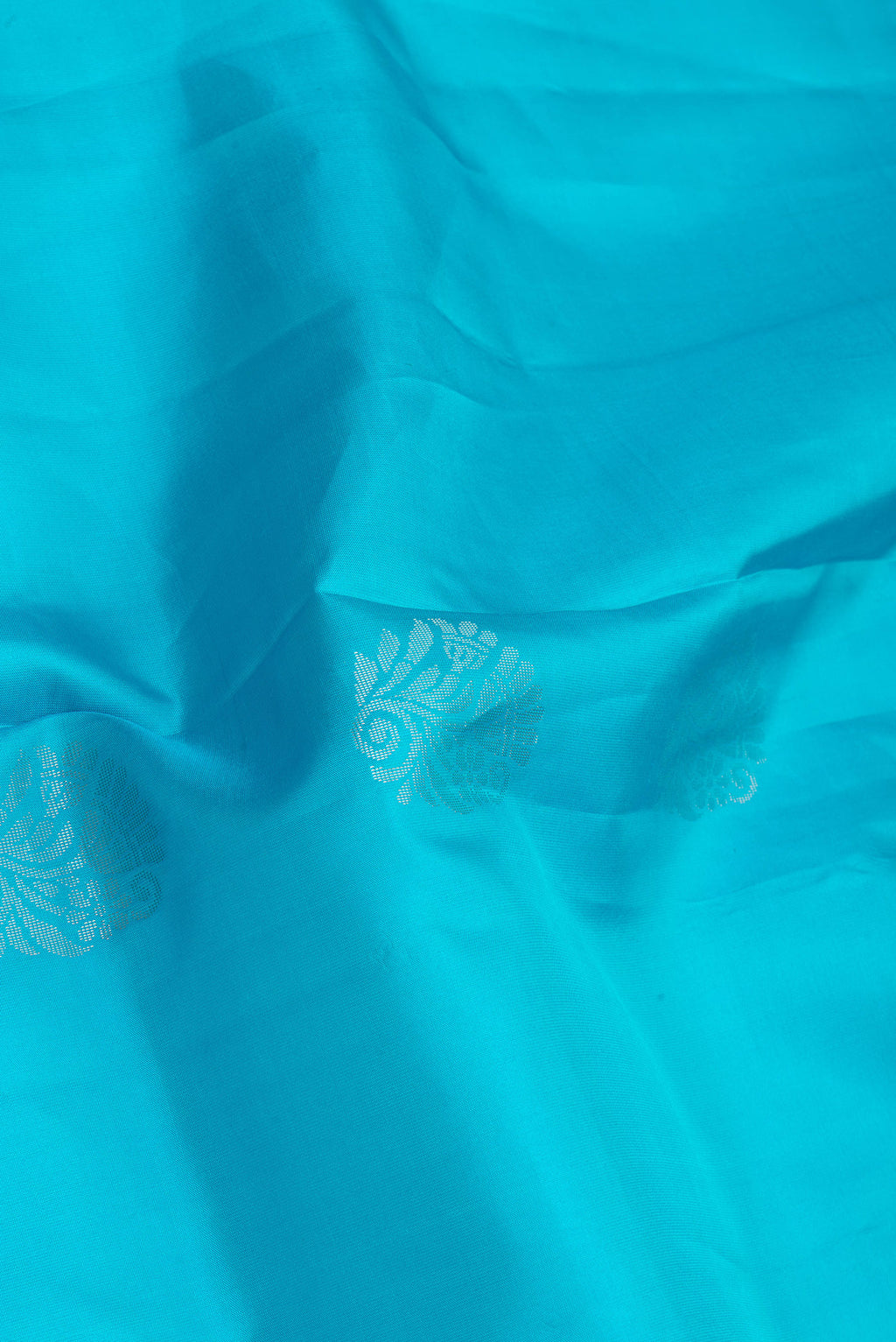 Close up of Sky Blue Soft Silk Saree with Zari Butta on the body and Fancy Border.  displaying folds