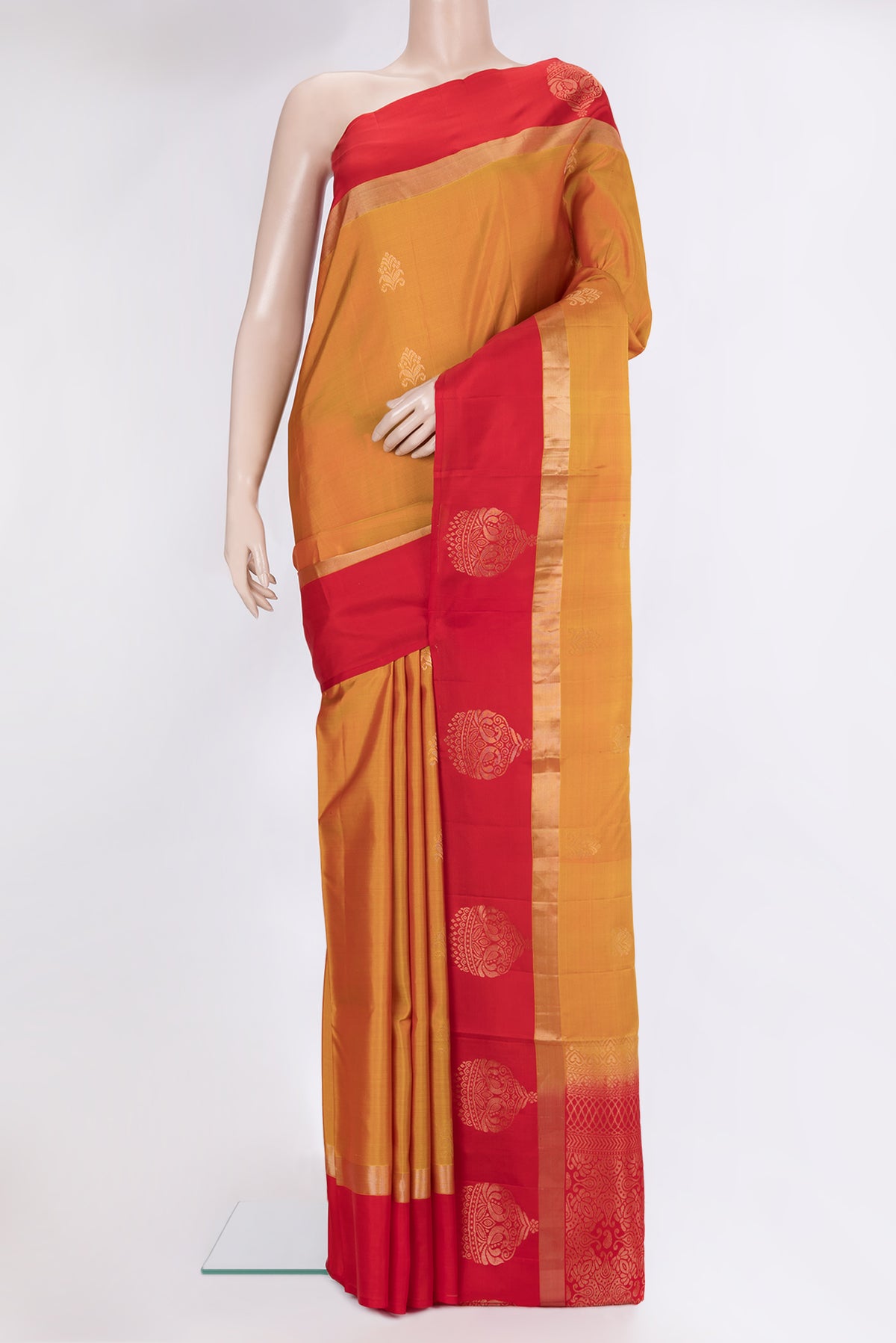 Mustard Soft Silk Saree with Zari Butta on the body and Fancy Border.  displayed on a mannequin