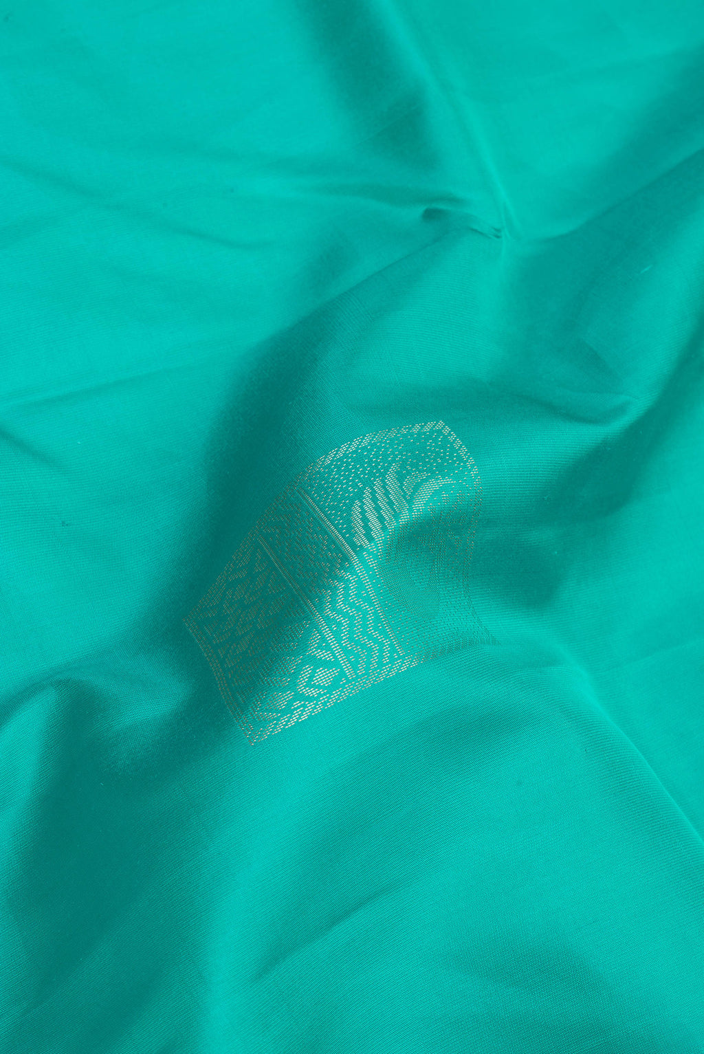 Close up of Sea Green Soft Silk Saree with Zari Butta on the body and Zari Border.  displaying folds