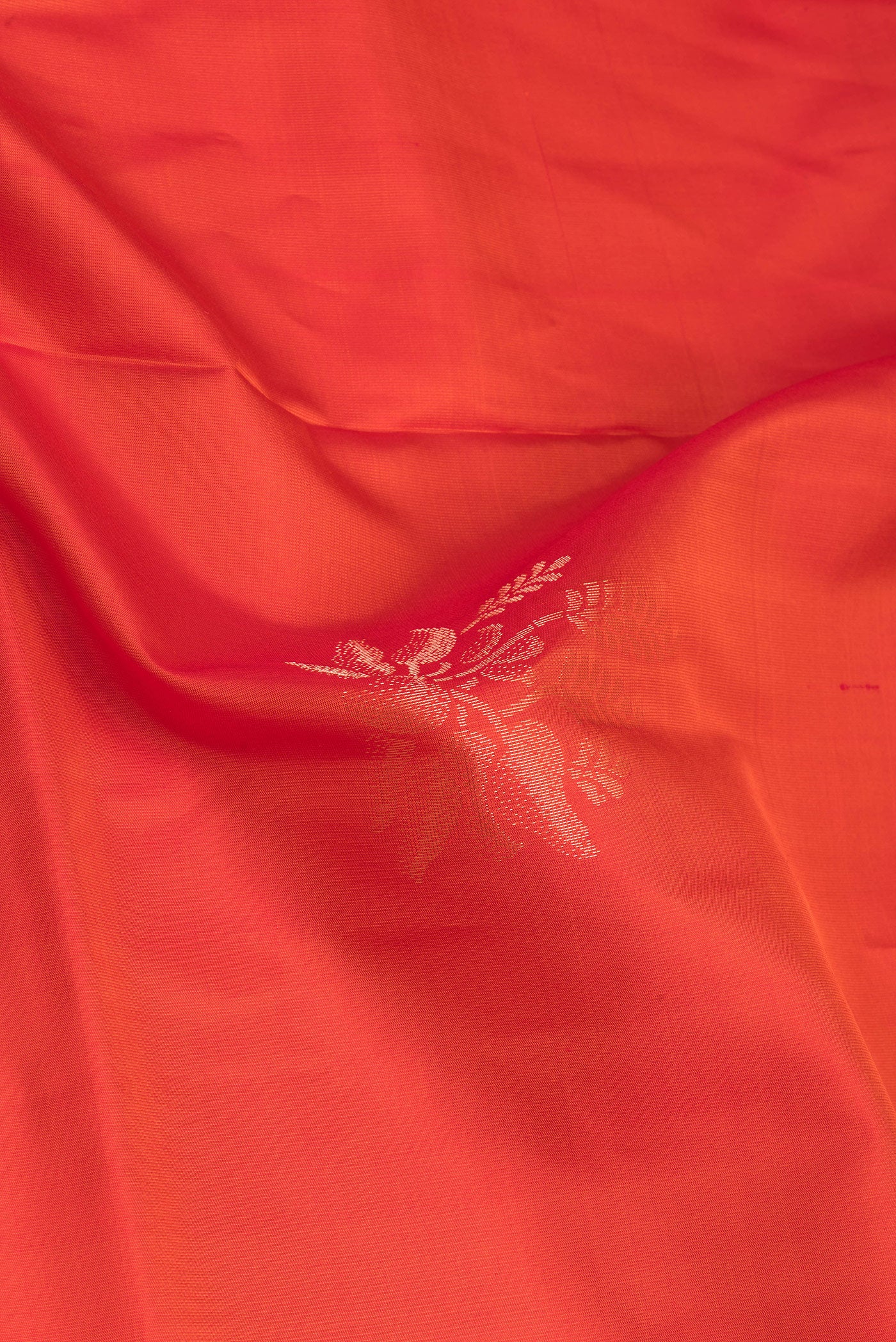Close up of Orange Soft Silk Saree with Zari Butta on the body and Zari Border.  displaying folds