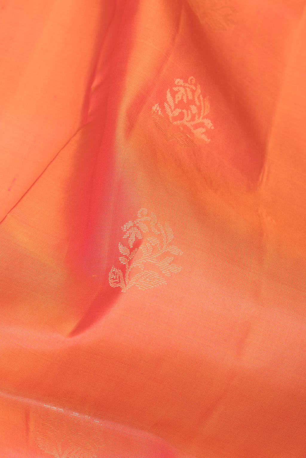 Close up of Orange Soft Silk Saree with Zari Butta on the body and Fancy Border.  displaying folds