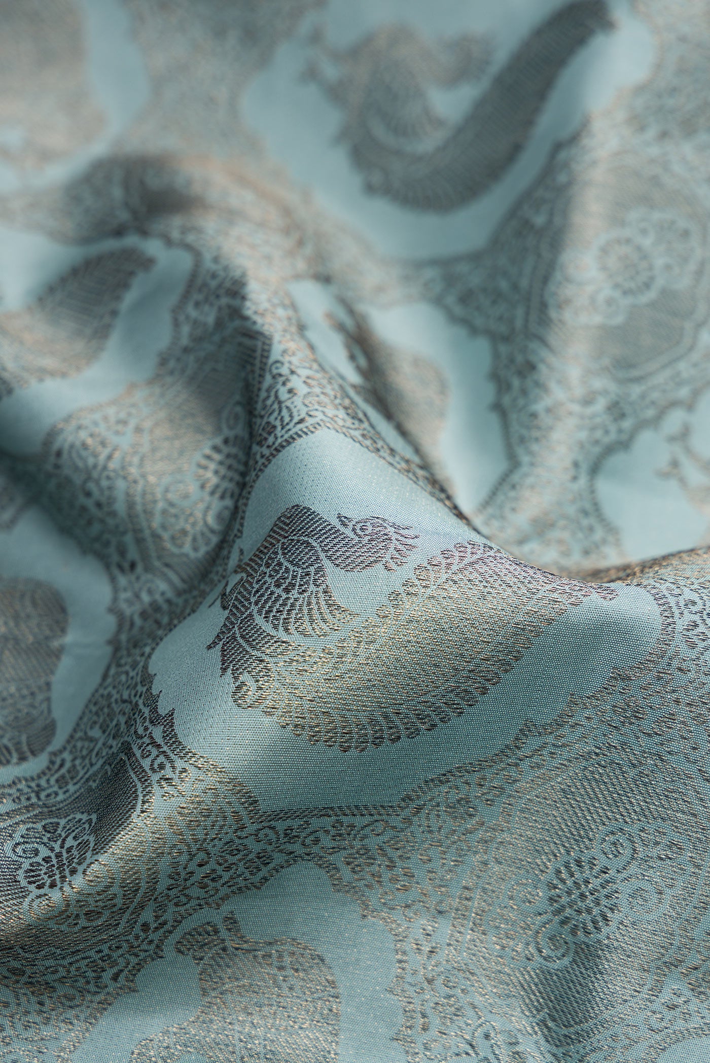 Close up of Grey Dual Tone Kanjivaram Silk Saree with Jacquard design on the body and Fancy Border.  displaying folds