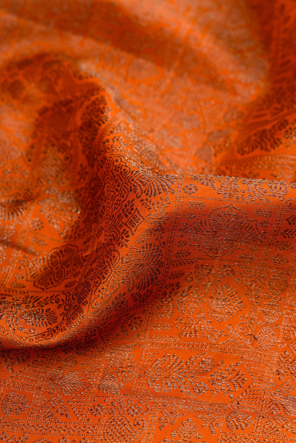 Close up of Brick Orange Dual Tone Kanjivaram Silk Saree with Jacquard design on the body and Fancy Border.  displaying folds