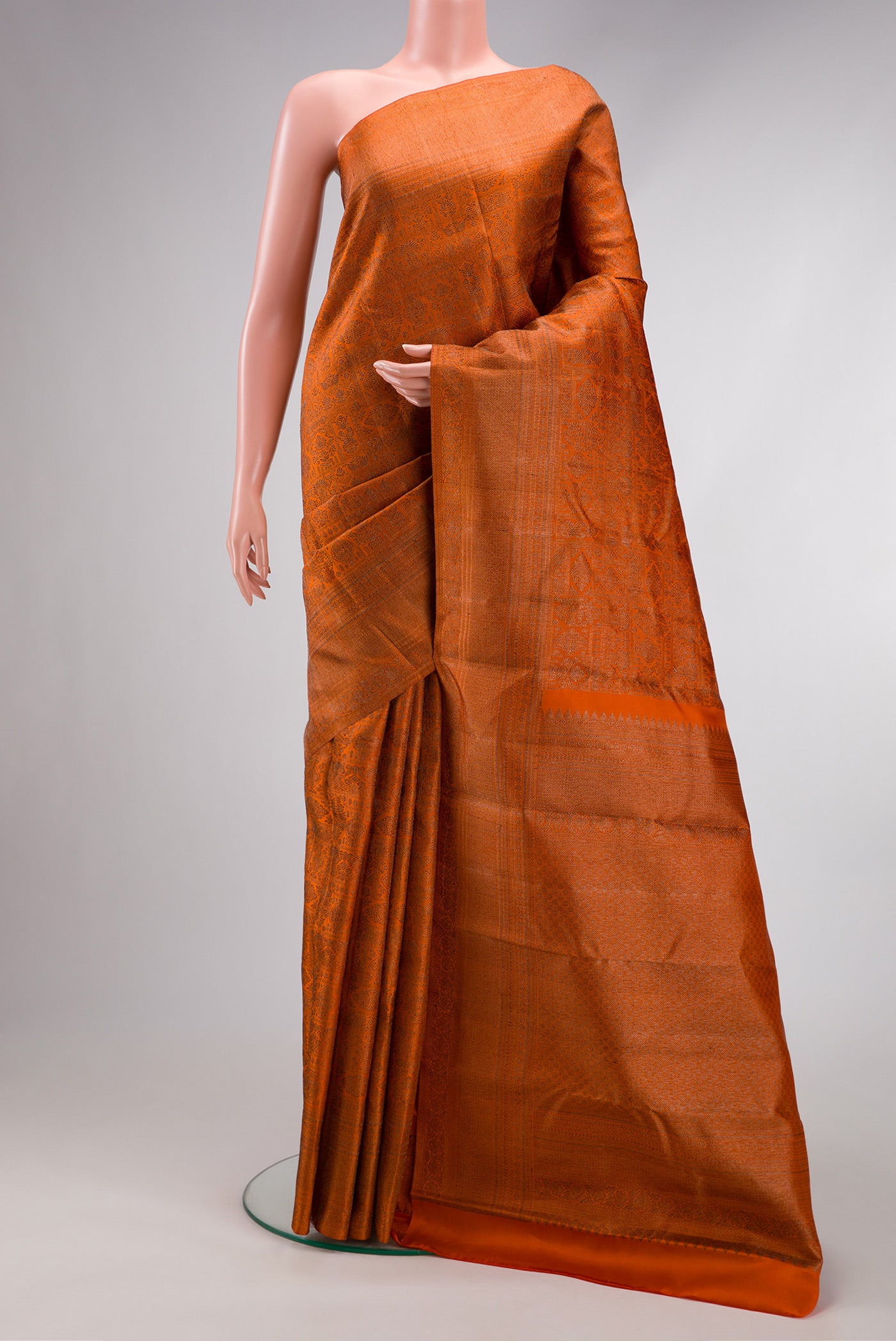 Brick Orange Dual Tone Kanjivaram Silk Saree with Jacquard design on the body and Fancy Border.  displayed on a mannequin
