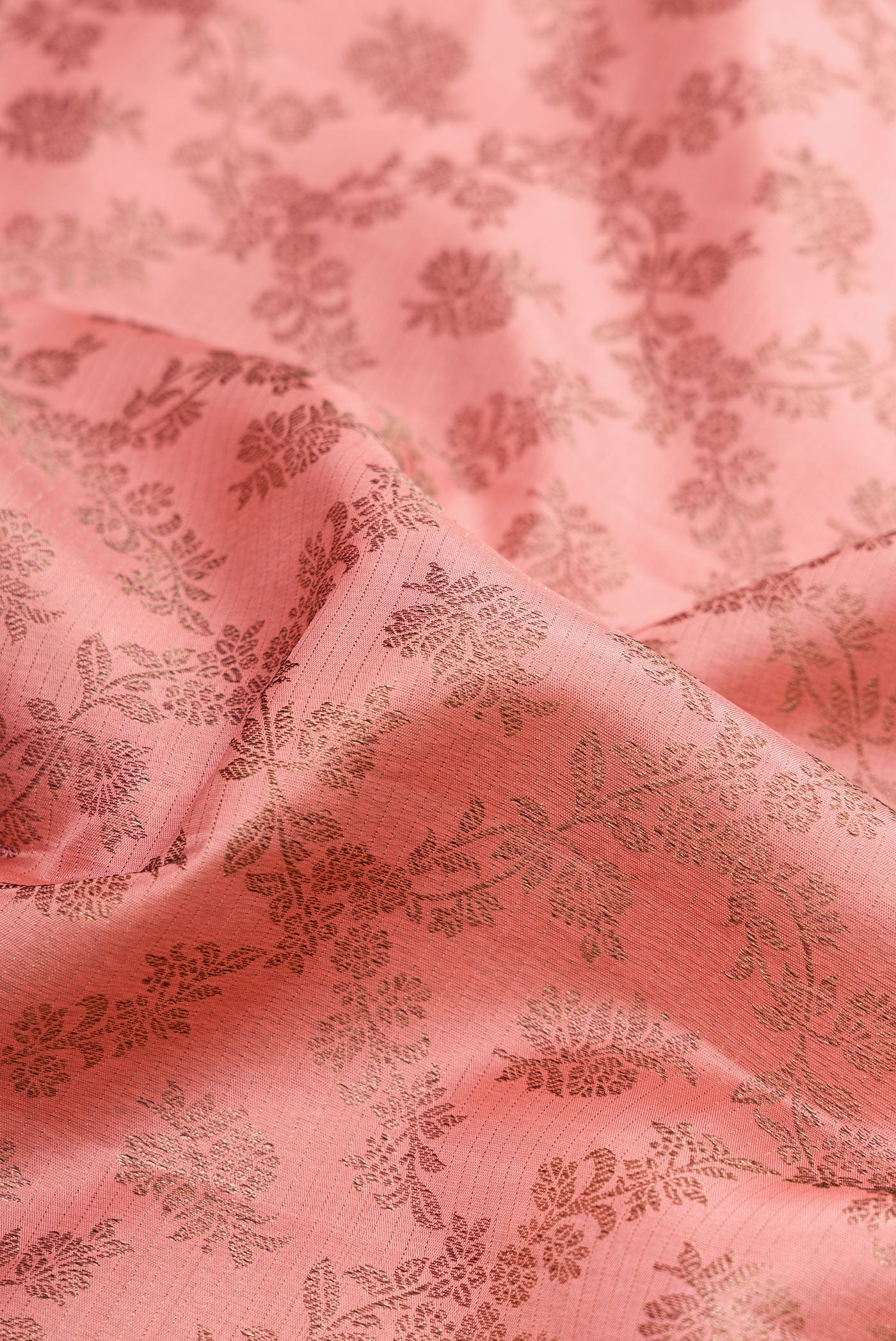 Close up of Peach Kanjivaram Silk Saree with Zari Brocade on the body and Fancy Border.  displaying folds