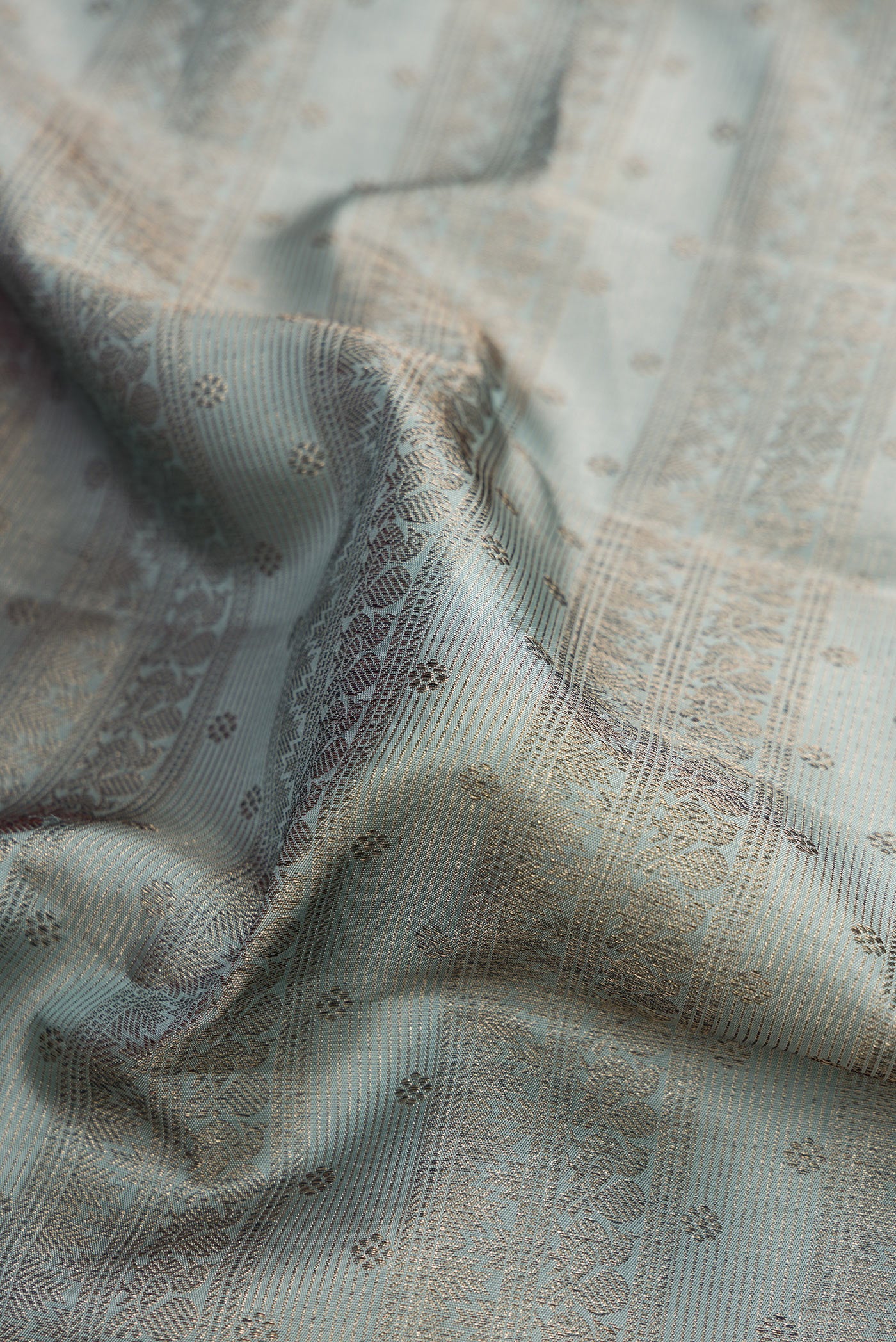 Close up of Grey Kanjivaram Silk Saree with Zari Brocade on the body and Fancy Border.  displaying folds