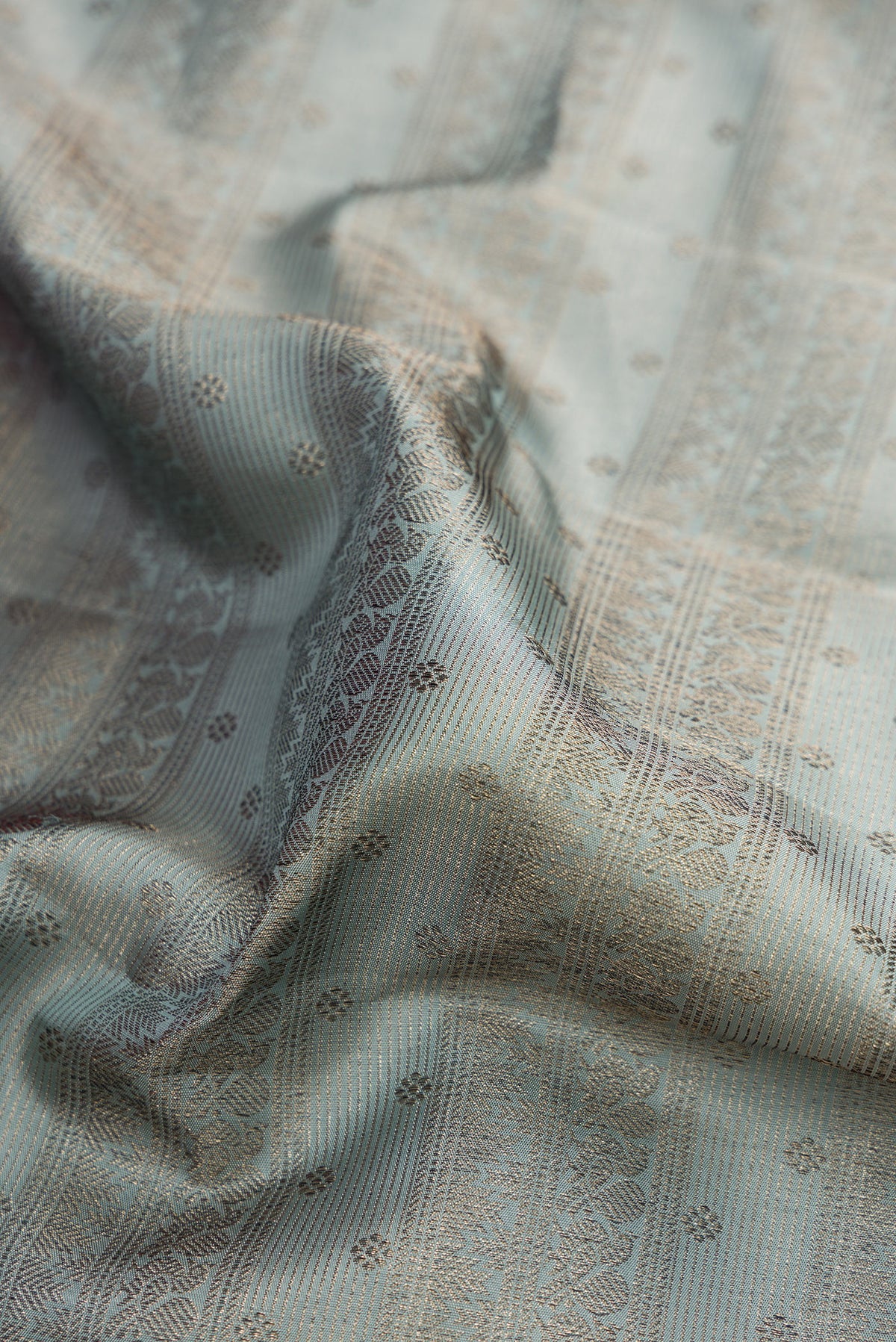 Close up of Grey Kanjivaram Silk Saree with Zari Brocade on the body and Fancy Border.  displaying folds