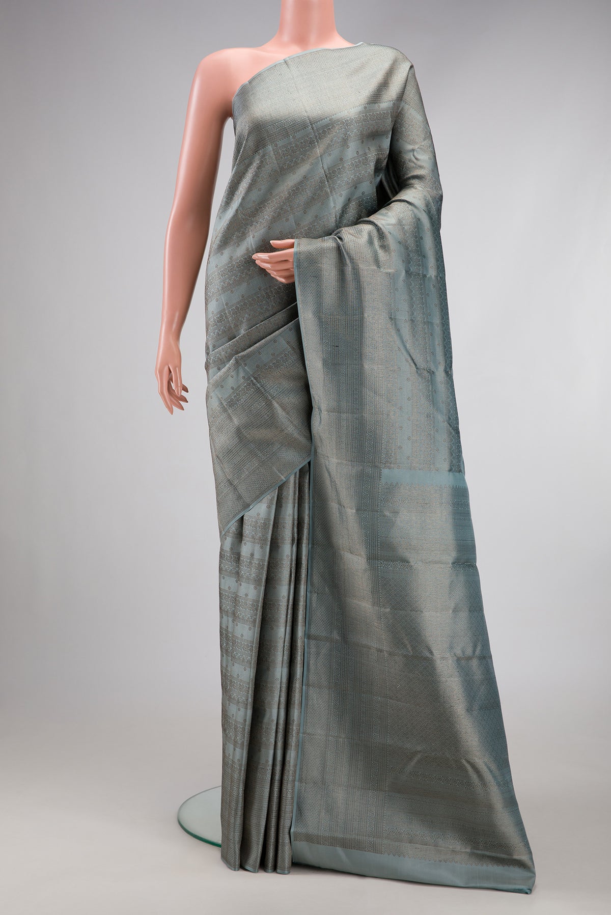 Grey Kanjivaram Silk Saree with Zari Brocade on the body and Fancy Border.  displayed on a mannequin