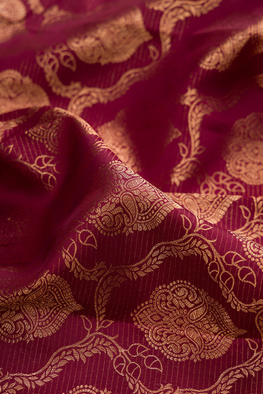 Close up of Maroon Kanjivaram Silk Saree with Zari Brocade on the body and Fancy Border.  displaying folds