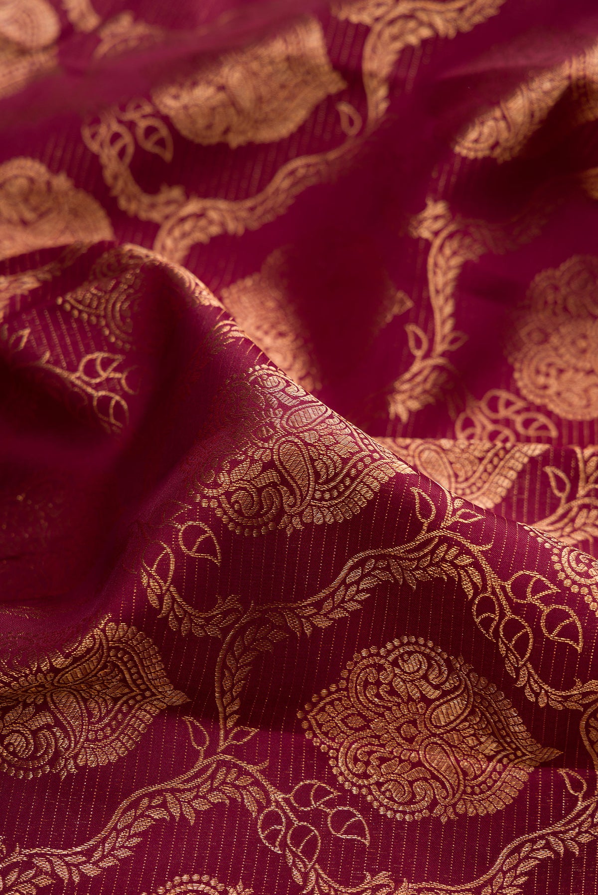 Close up of Maroon Kanjivaram Silk Saree with Zari Brocade on the body and Fancy Border.  displaying folds