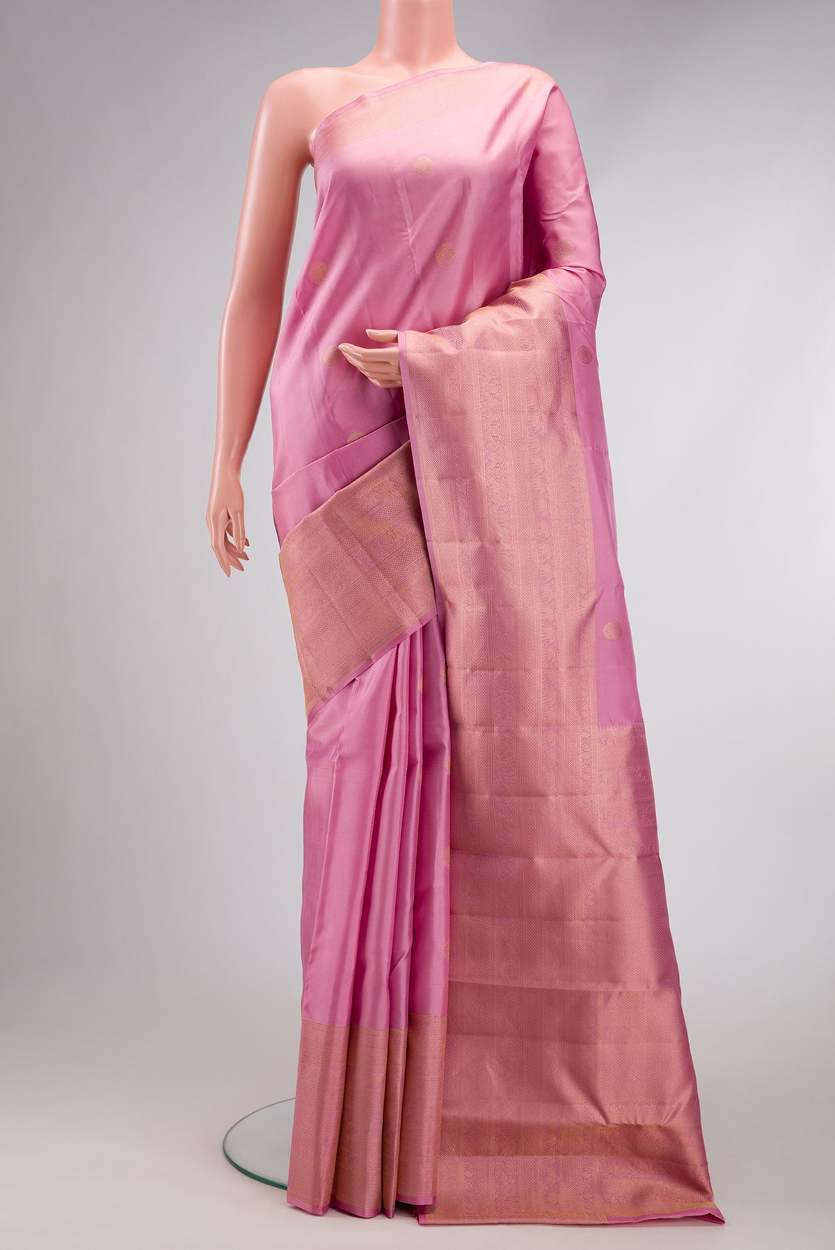 Rose pink Kanjivaram Silk Saree with Zari Butta on the body and Fancy Border.  displayed on a mannequin
