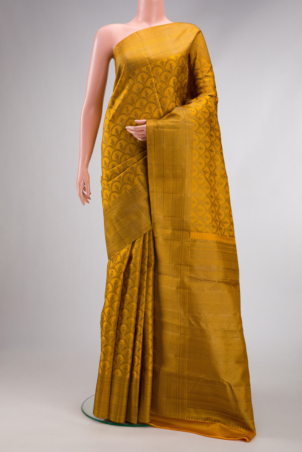 Mustard Kanjivaram Silk Saree with Jacquard design on the body and Fancy Border.  displayed on a mannequin