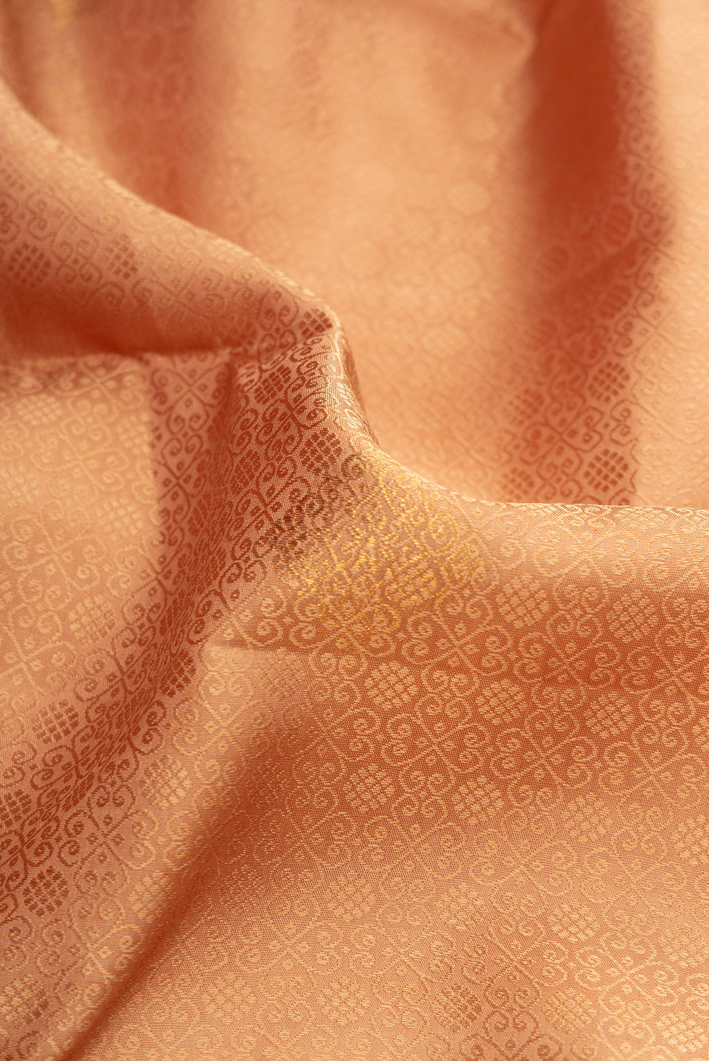 Close up of Golden Peach Dual Tone Kanjivaram Silk Saree with Jacquard With Zari Butta on the body and Fancy Border.  displaying folds
