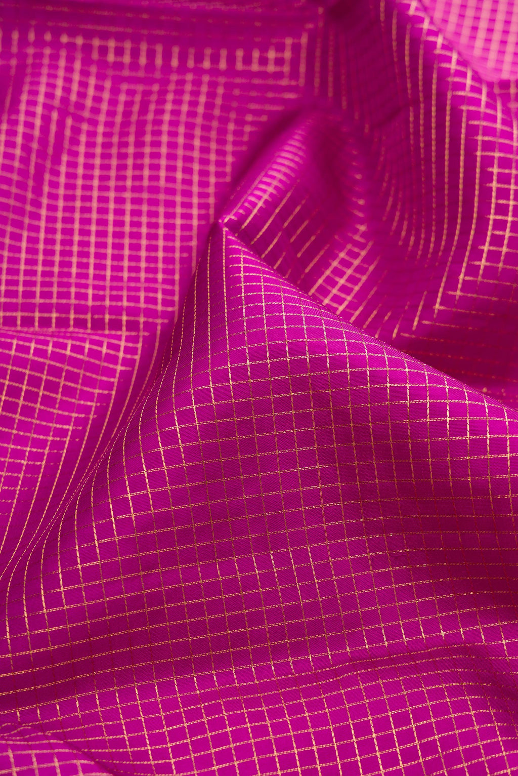 Close up of Magenta Kanjivaram Silk Saree with Checked design on the body and Zari Border.  displaying folds