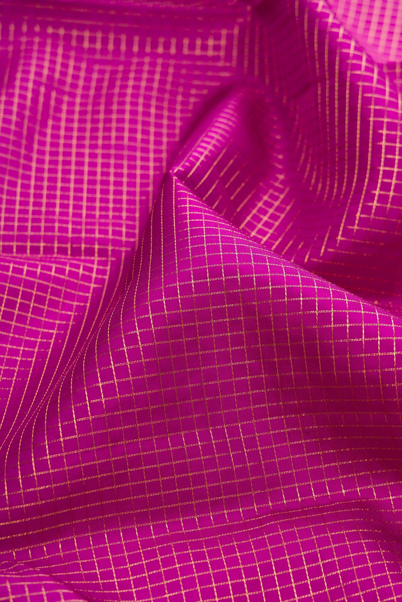 Close up of Magenta Kanjivaram Silk Saree with Checked design on the body and Zari Border.  displaying folds