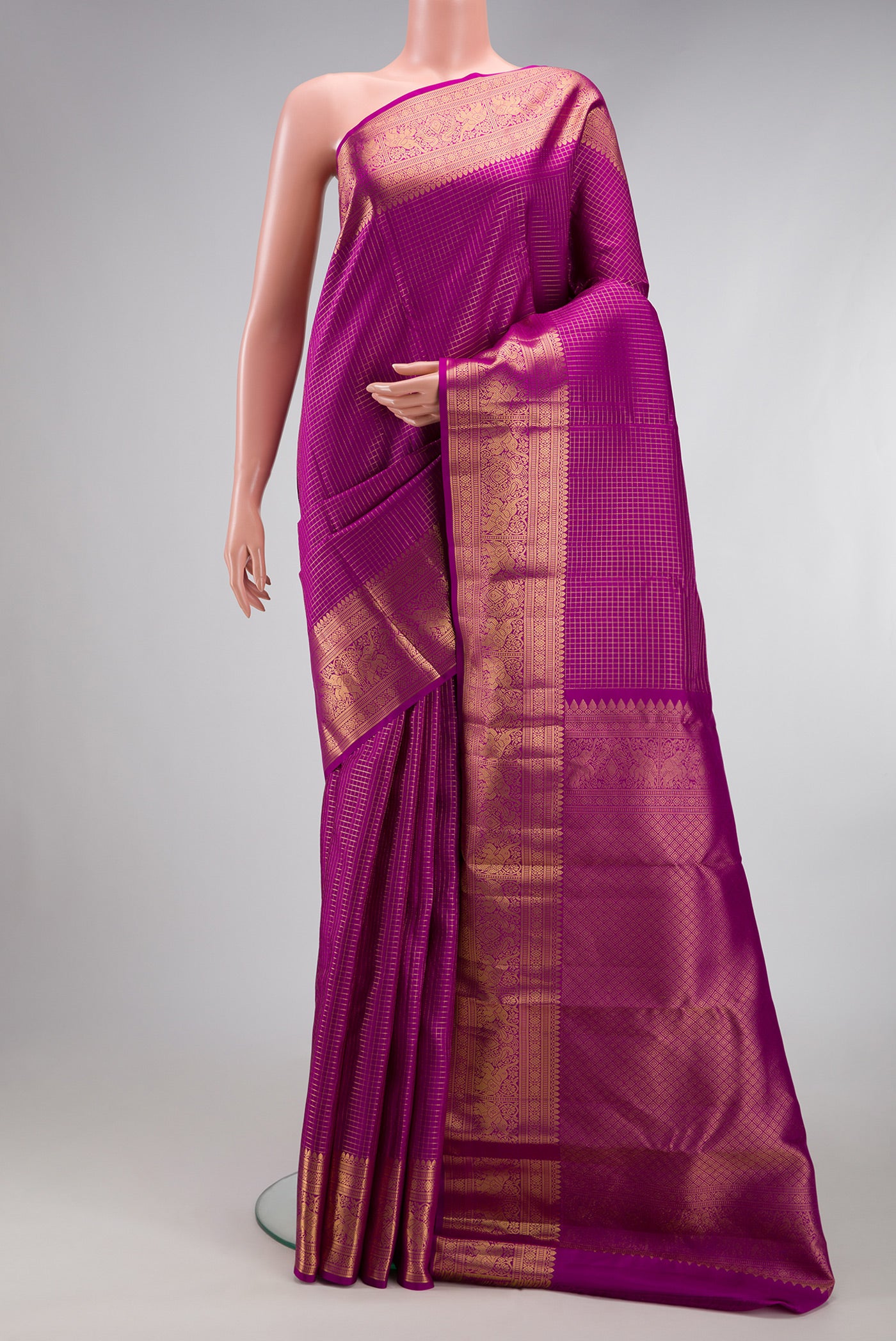 Magenta Kanjivaram Silk Saree with Checked design on the body and Zari Border.  displayed on a mannequin