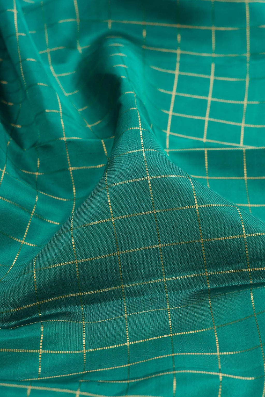 Close up of Teal Kanjivaram Silk Saree with Checked design on the body and Zari Border.  displaying folds