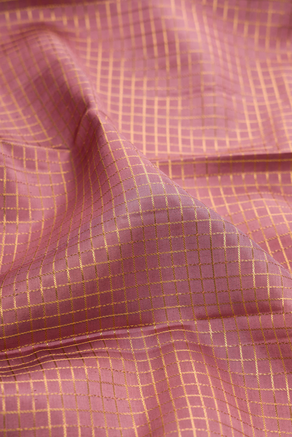 Close up of Mauve Kanjivaram Silk Saree with Checked design on the body and Zari Border.  displaying folds