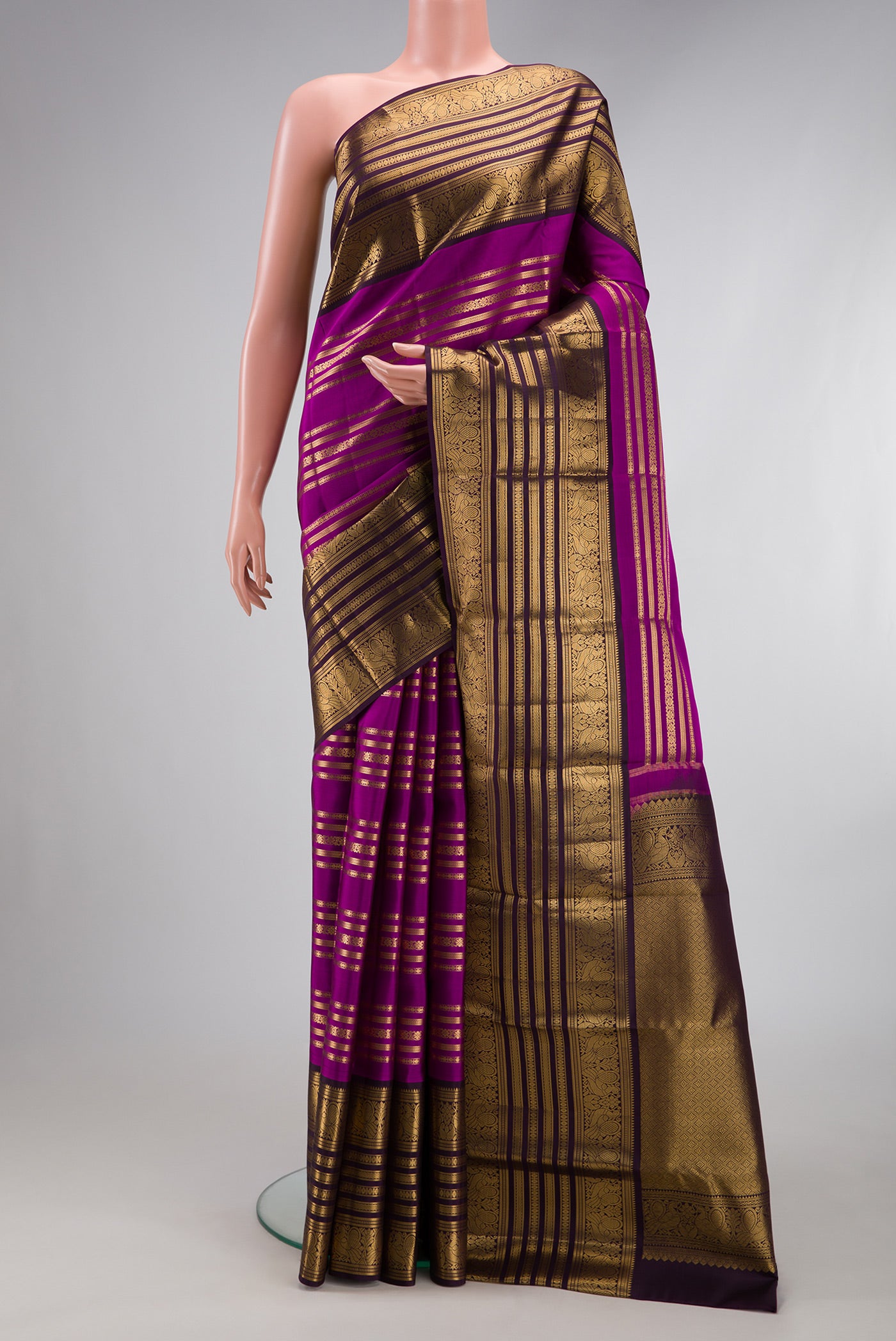 Magenta Kanjivaram Silk Saree with Stripes on the body and Zari Border.  displayed on a mannequin