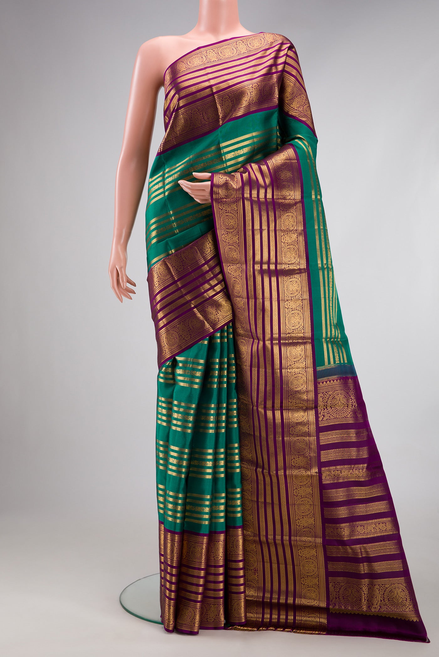 Green Kanjivaram Silk Saree with Stripes on the body and Zari Border.  displayed on a mannequin