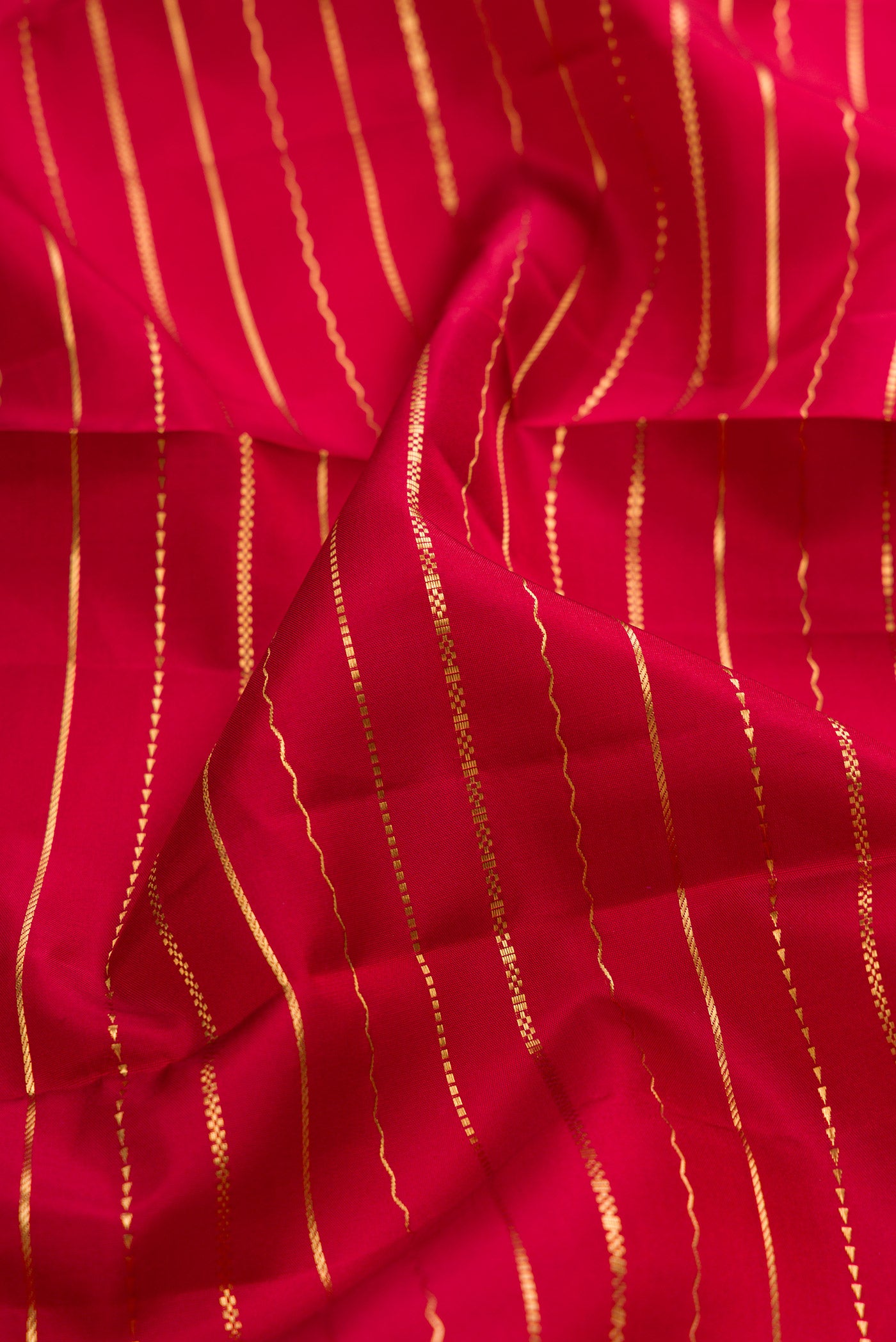 Close up of Maroon Kanjivaram Silk Saree with Stripes on the body and Zari Border.  displaying folds