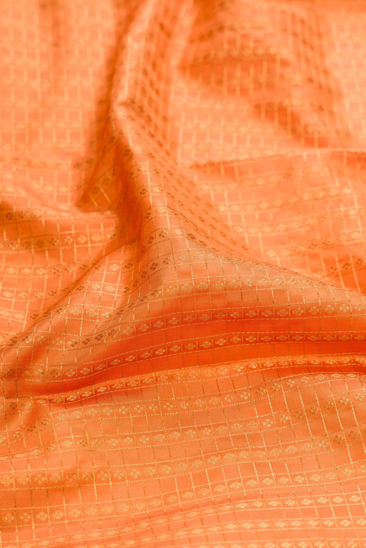 Close up of Orange Kanjivaram Silk Saree with Zari Brocade on the body and Zari Border.  displaying folds