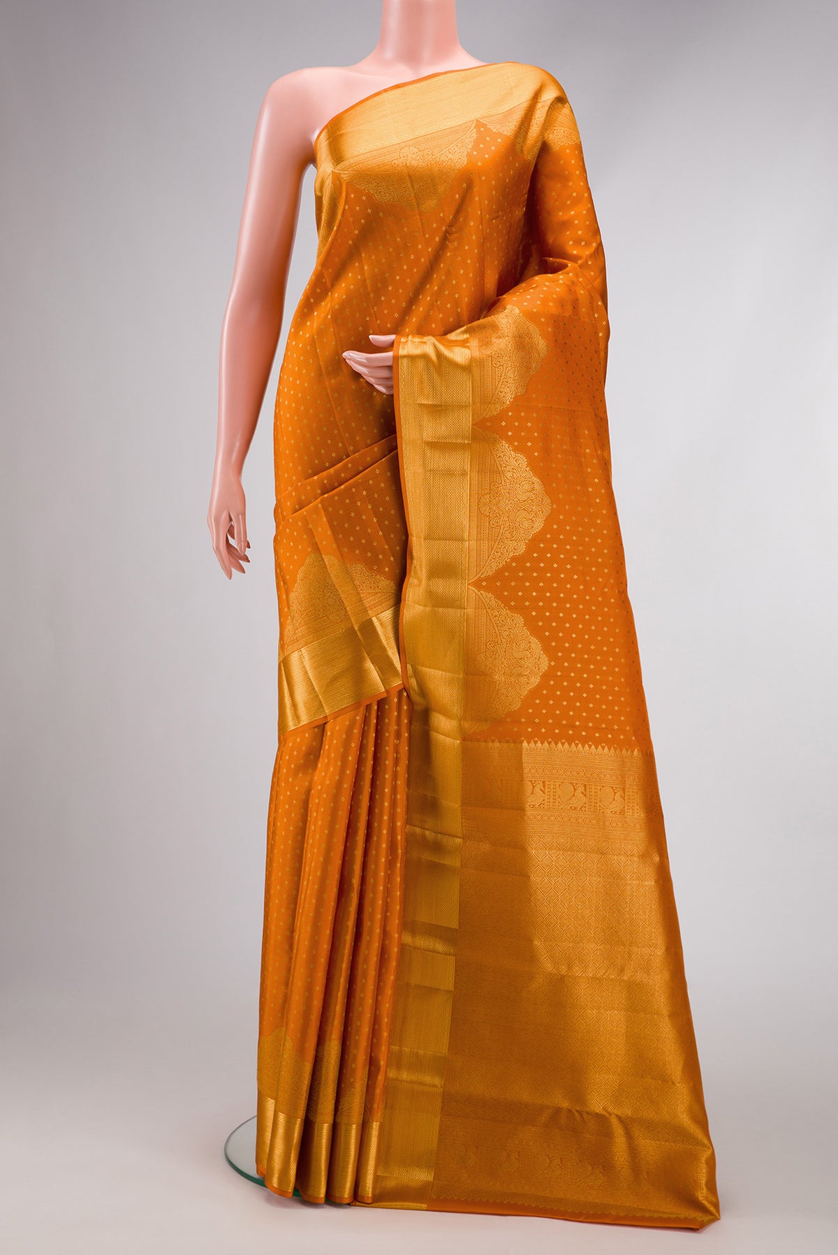 Orange Dual Tone Kanjivaram Silk Saree with Zari Butta on the body and Fancy Border.  displayed on a mannequin