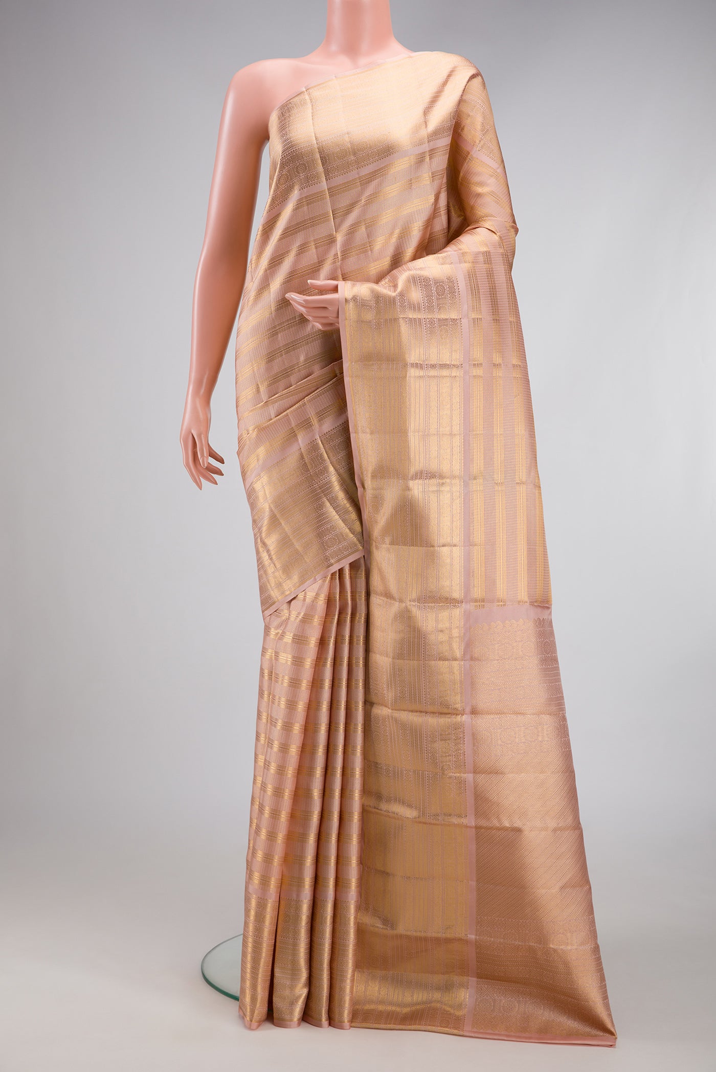 Peach Kanjivaram Silk Saree with Checked design on the body and Zari Border.  displayed on a mannequin