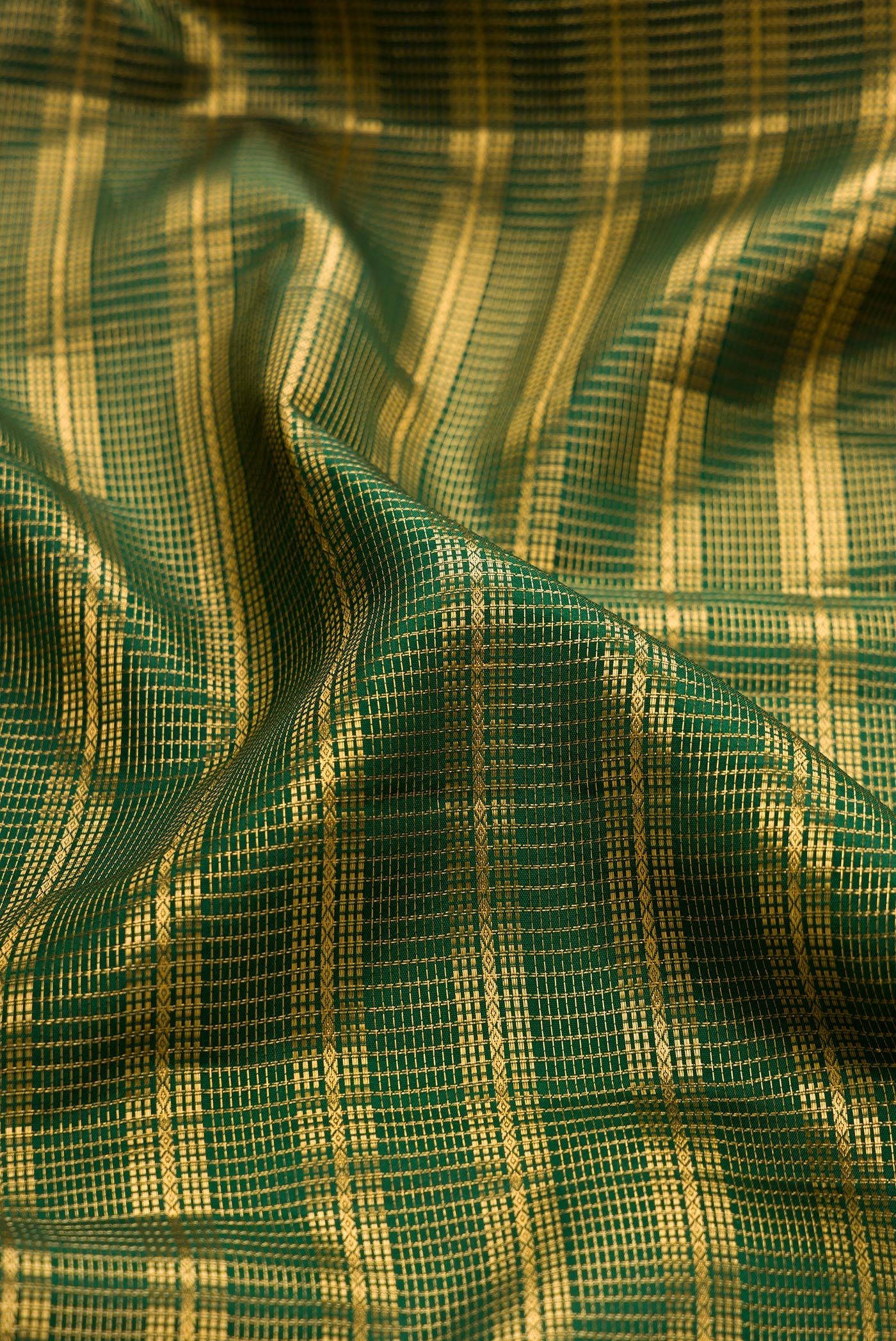 Close up of Bottle Green Kanjivaram Silk Saree with Stripes on the body and Zari Border.  displaying folds