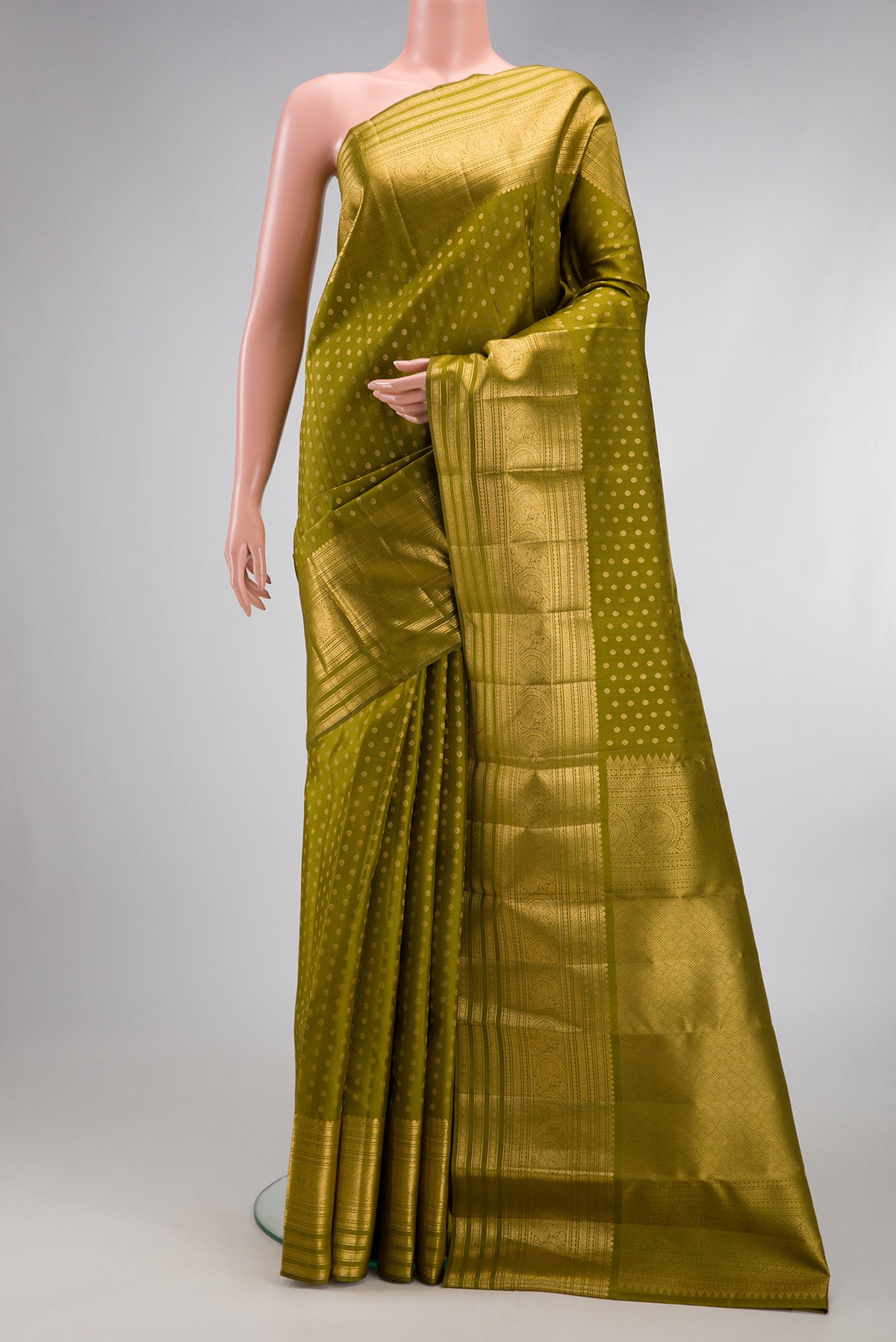 Mehandi Green Kanchipuram Silk Saree with Zari Butta on the body and Zari Border.  displayed on a mannequin
